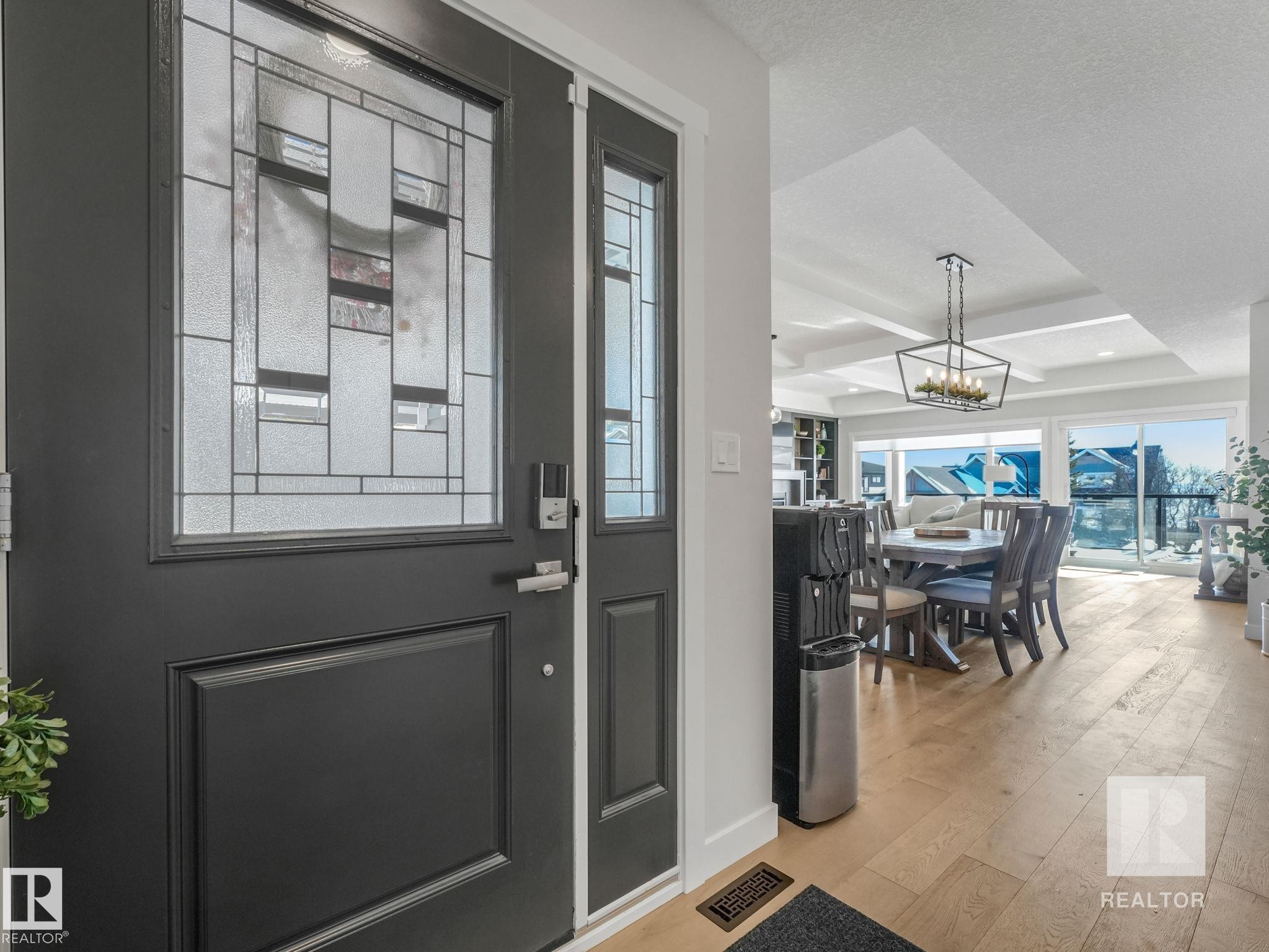 Foyer featuring light wood-style flooring, coffered ceiling, a chandelier, and a textured ceiling - 209 55101 Ste. Anne Trail, Rural Lac Ste. Anne County, AB - Indoor Photo Showing Other Room