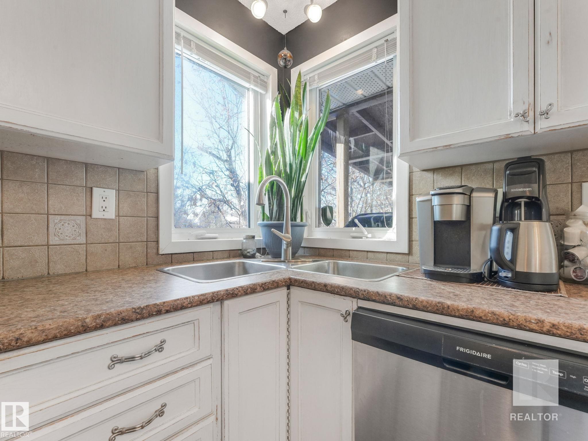 Kitchen featuring tasteful backsplash, stainless steel dishwasher, and white cabinetry - 4504 48 Avenue, Onoway, AB - Indoor Photo Showing Kitchen With Double Sink
