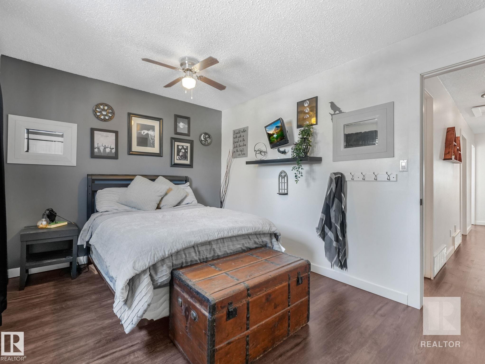 Bedroom featuring dark wood finished floors, a textured ceiling, and ceiling fan - 4504 48 Avenue, Onoway, AB - Indoor Photo Showing Bedroom