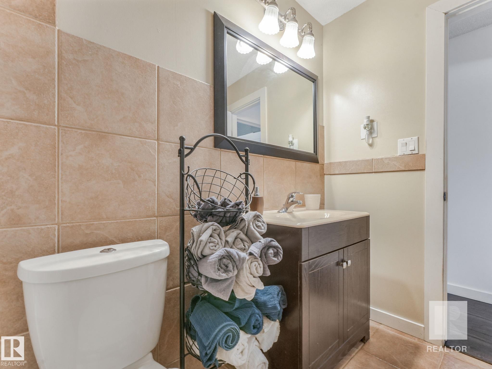 Bathroom with vanity, tile walls, and light tile patterned floors - 4504 48 Avenue, Onoway, AB - Indoor Photo Showing Bathroom