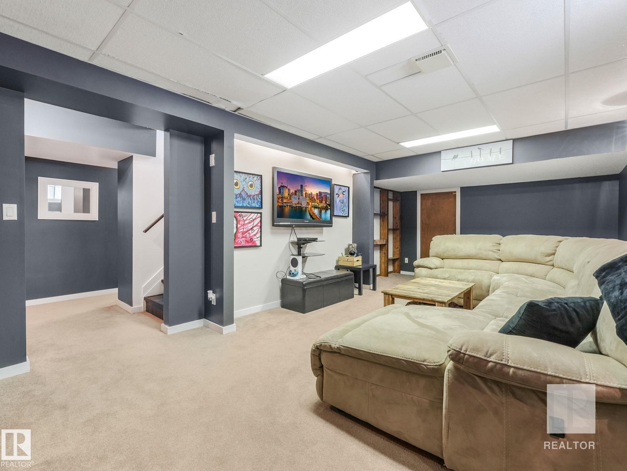 Living room featuring carpet floors and a drop ceiling - 4504 48 Avenue, Onoway, AB - Indoor Photo Showing Basement