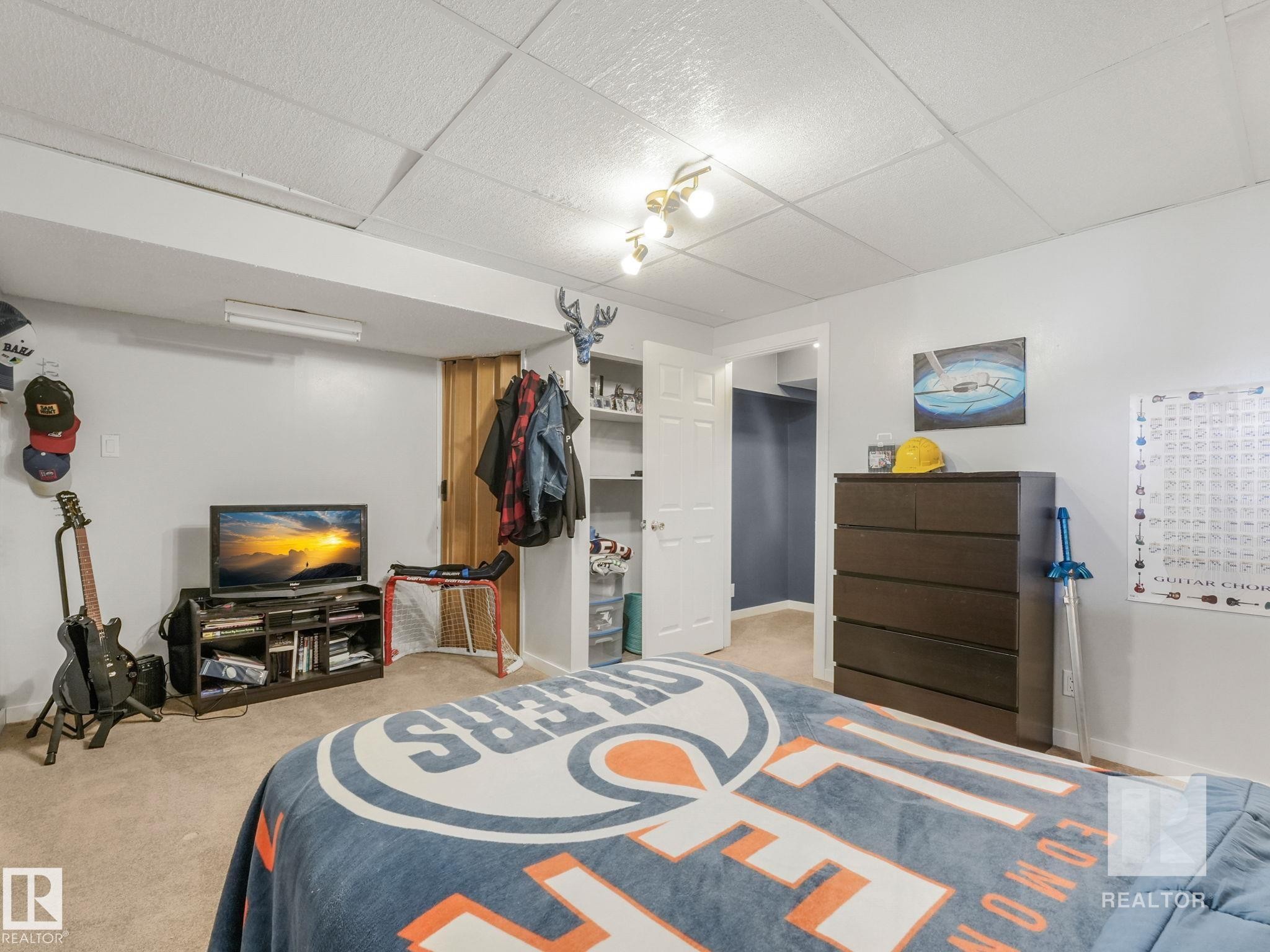Carpeted bedroom with a drop ceiling and a walk in closet - 4504 48 Avenue, Onoway, AB - Indoor