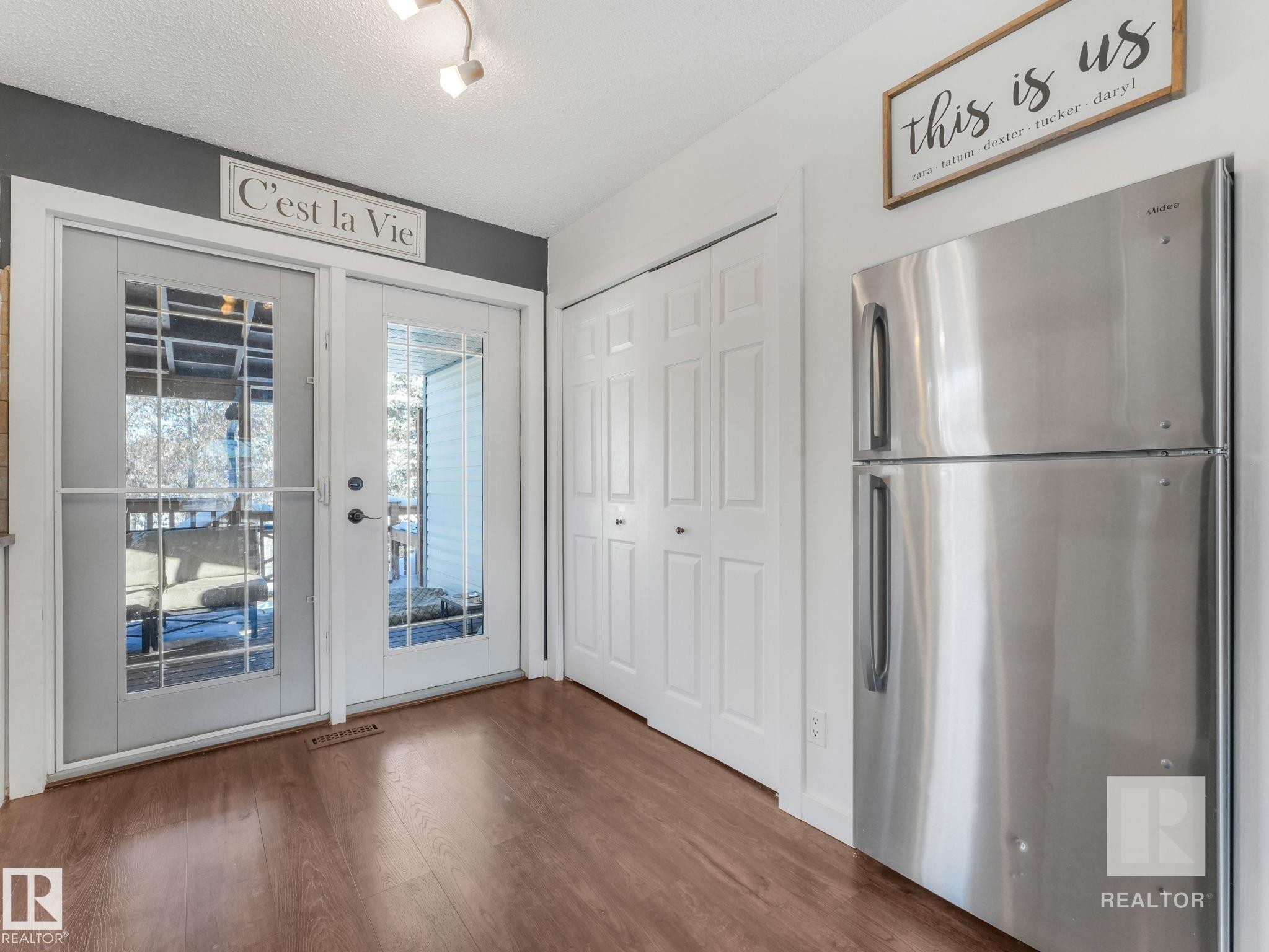 Unfurnished dining area featuring wood finished floors and a textured ceiling - 4504 48 Avenue, Onoway, AB - Indoor Photo Showing Other Room