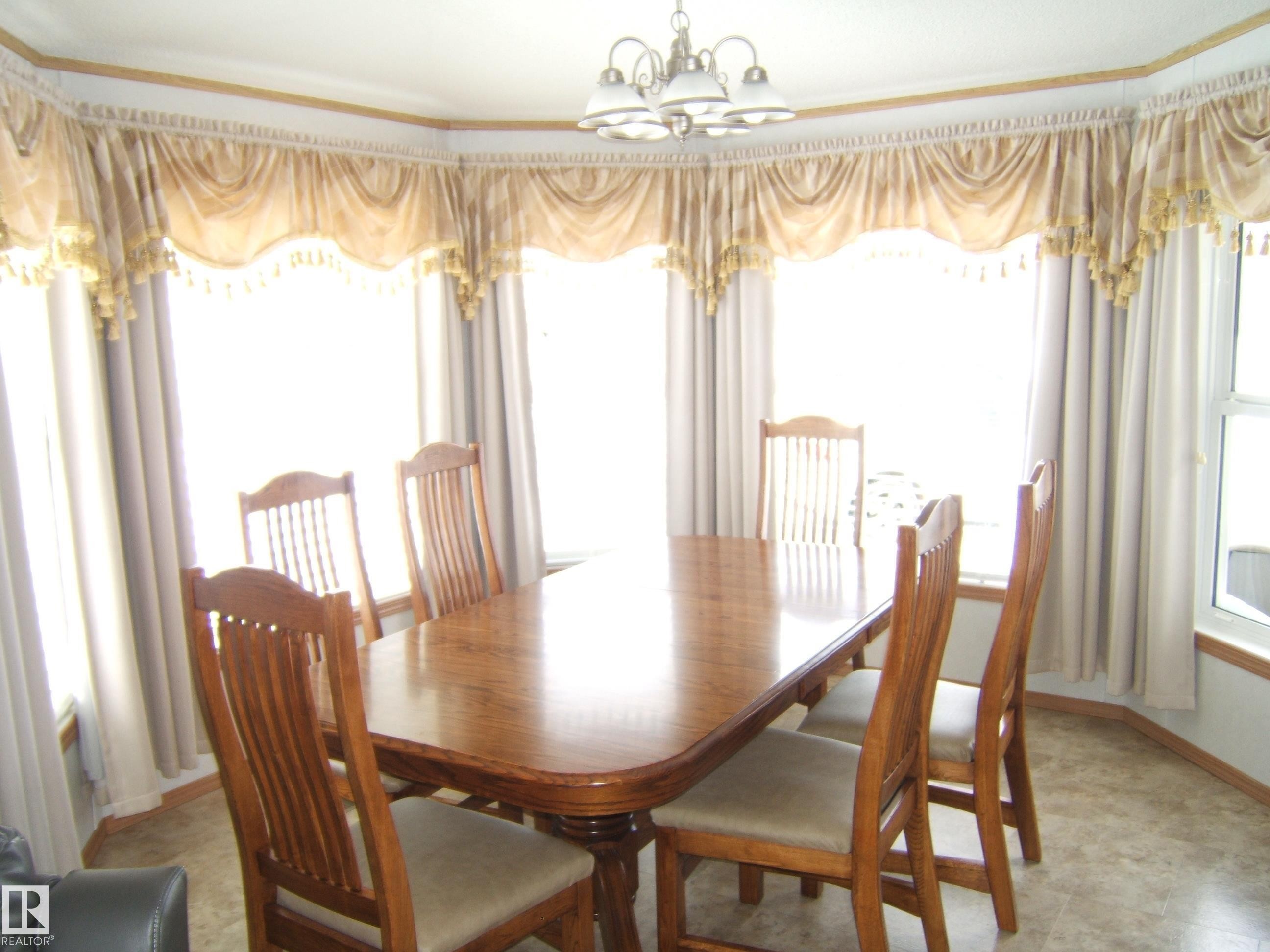 Dining area featuring a chandelier, plenty of natural light, and crown molding - 125076 Twp Rd 540, Rural Two Hills County, AB - Indoor Photo Showing Dining Room