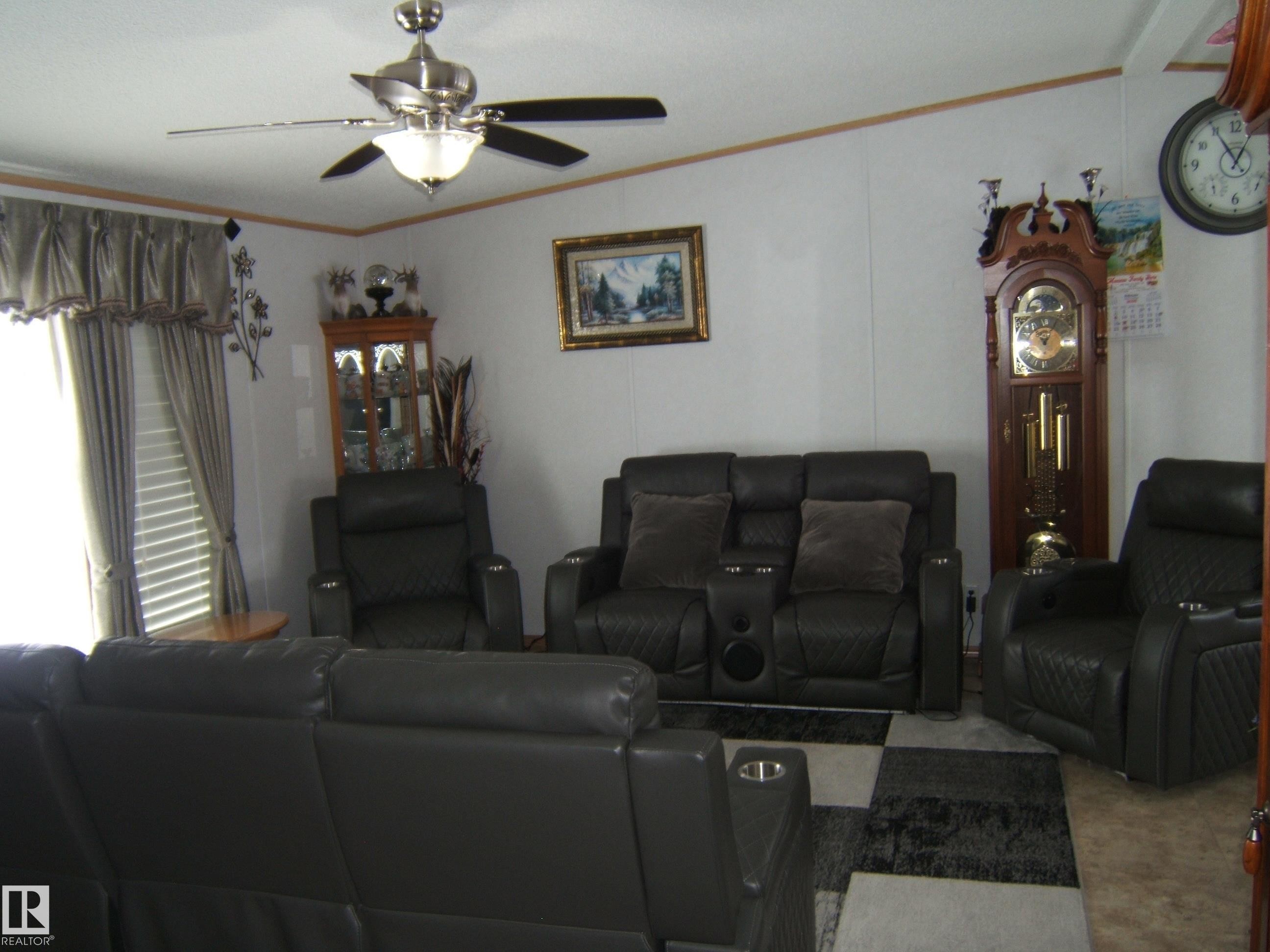 Carpeted living area with crown molding and ceiling fan - 125076 Twp Rd 540, Rural Two Hills County, AB - Indoor Photo Showing Living Room