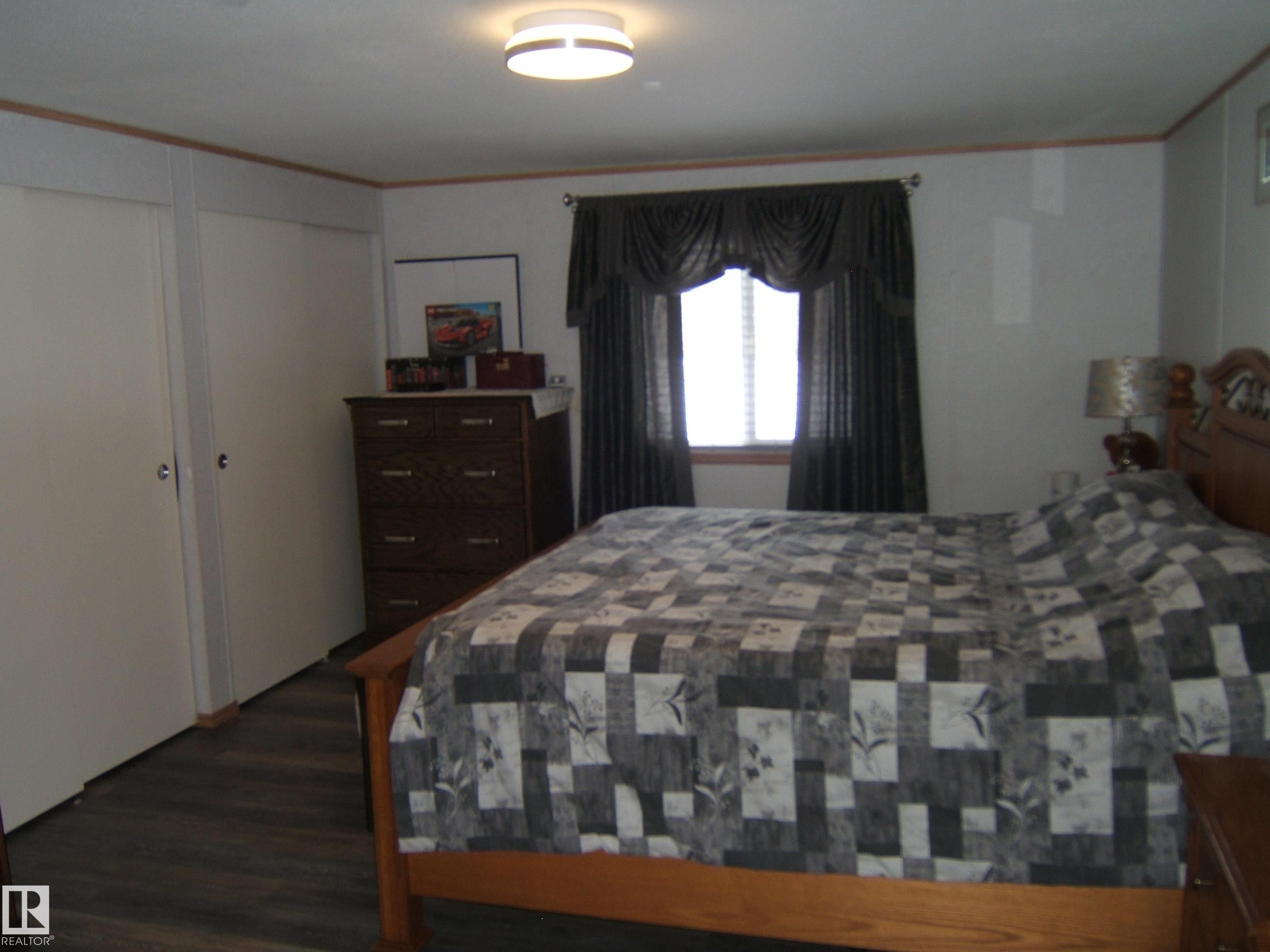 Bedroom with dark wood-style floors and ornamental molding - 125076 Twp Rd 540, Rural Two Hills County, AB - Indoor Photo Showing Bedroom