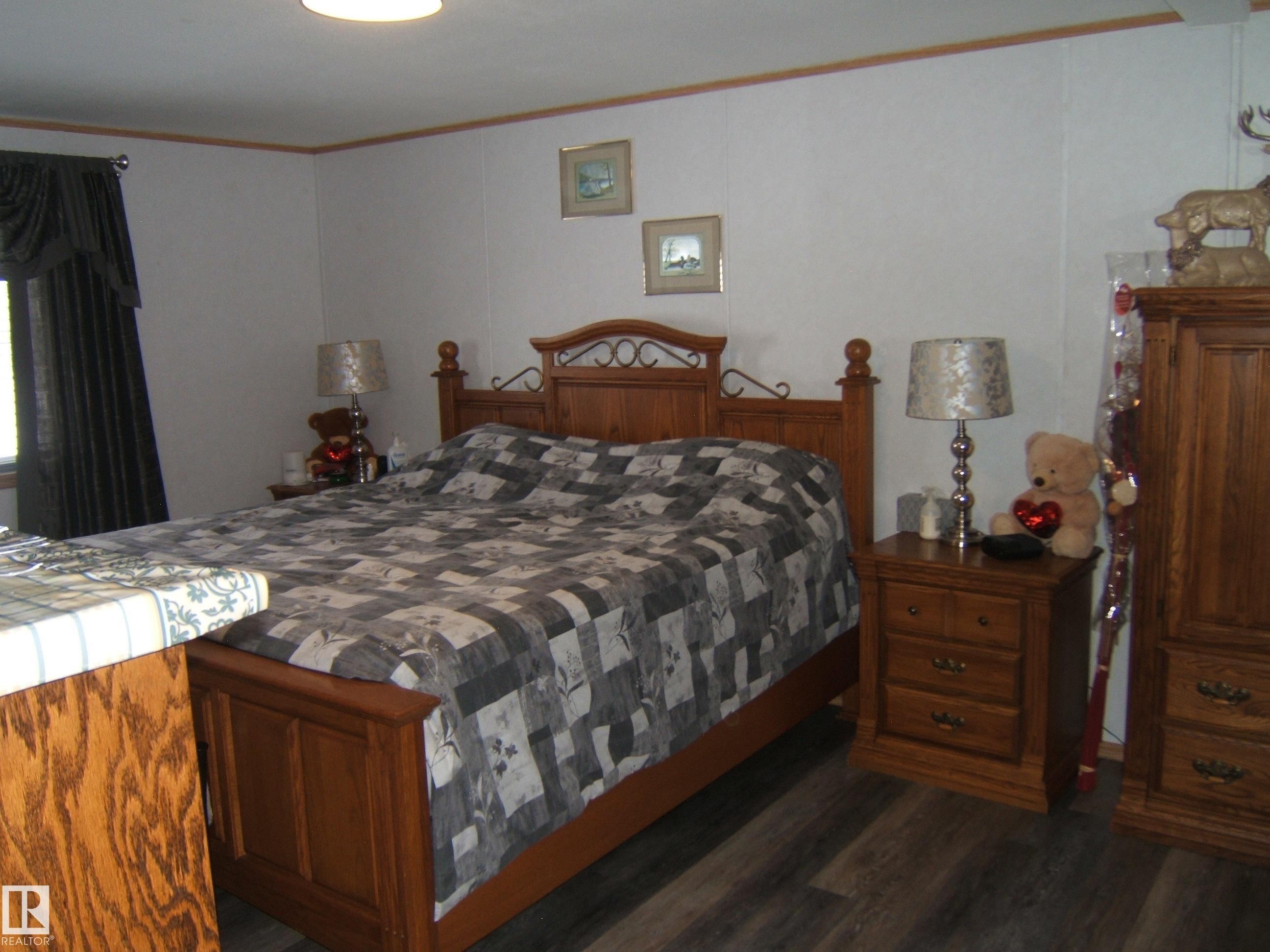 Bedroom with dark wood-style flooring and ornamental molding - 125076 Twp Rd 540, Rural Two Hills County, AB - Indoor Photo Showing Bedroom