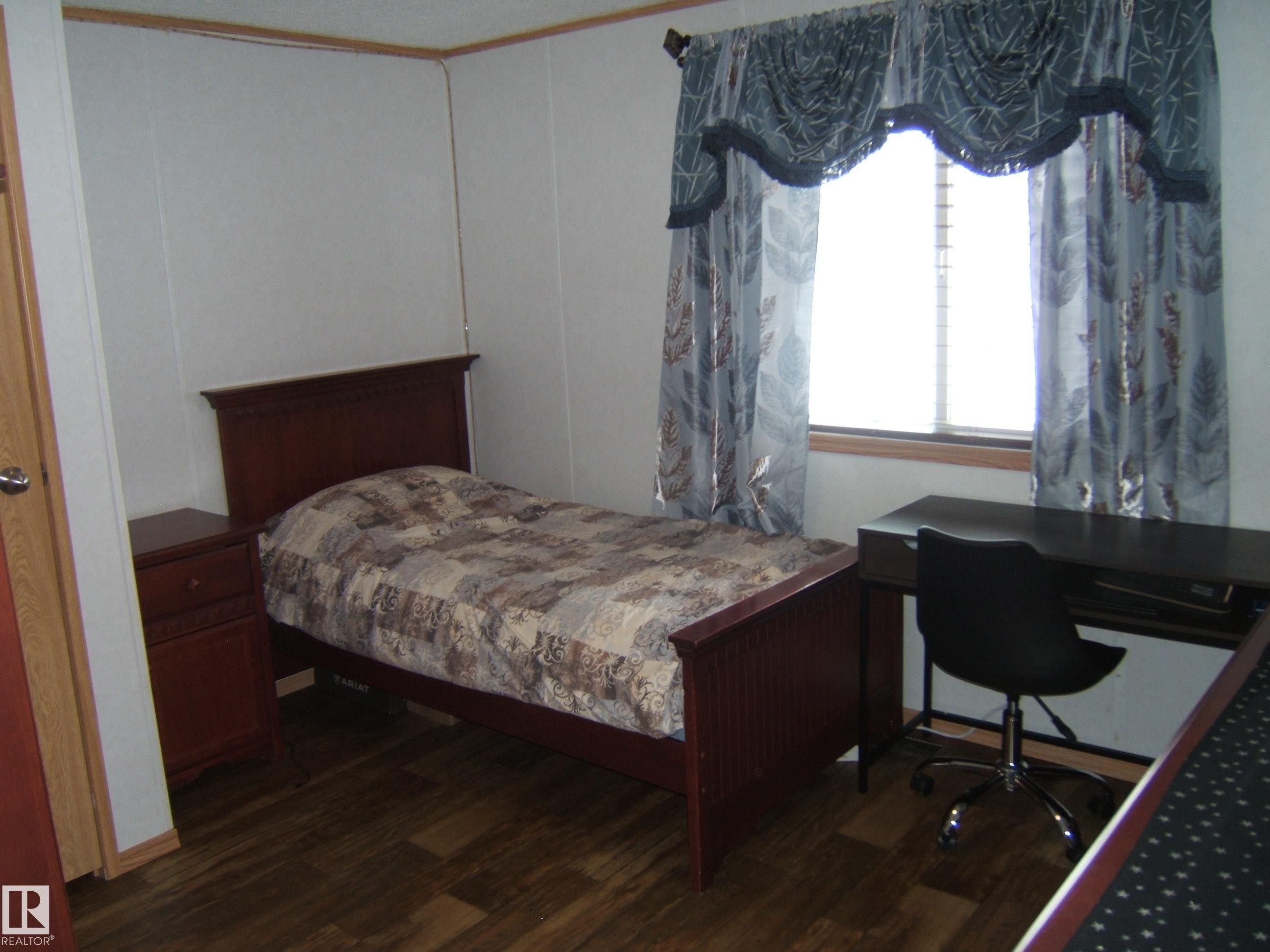 Bedroom featuring dark wood-type flooring and a desk - 125076 Twp Rd 540, Rural Two Hills County, AB - Indoor Photo Showing Bedroom