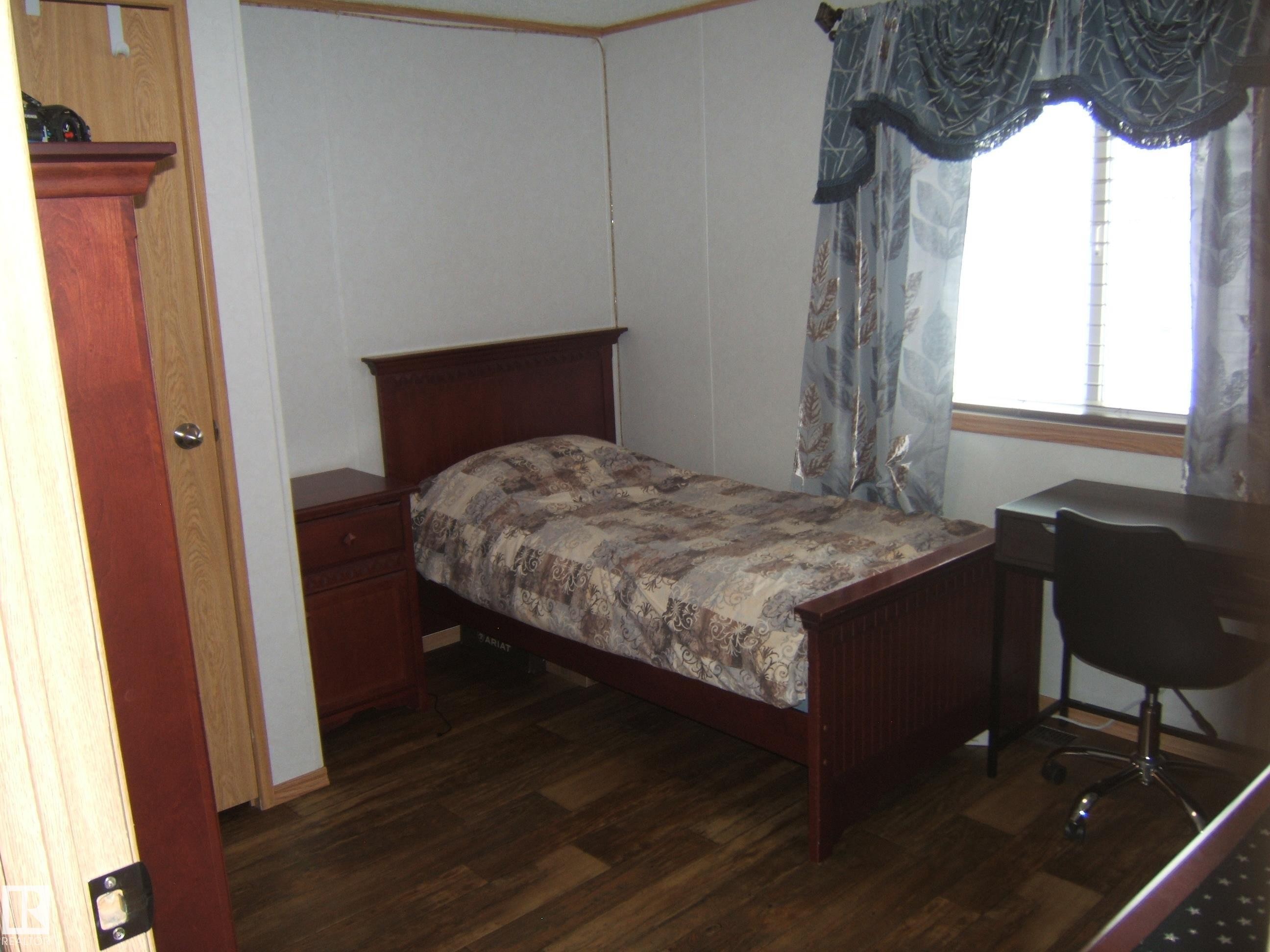 Bedroom featuring dark wood finished floors - 125076 Twp Rd 540, Rural Two Hills County, AB - Indoor Photo Showing Bedroom