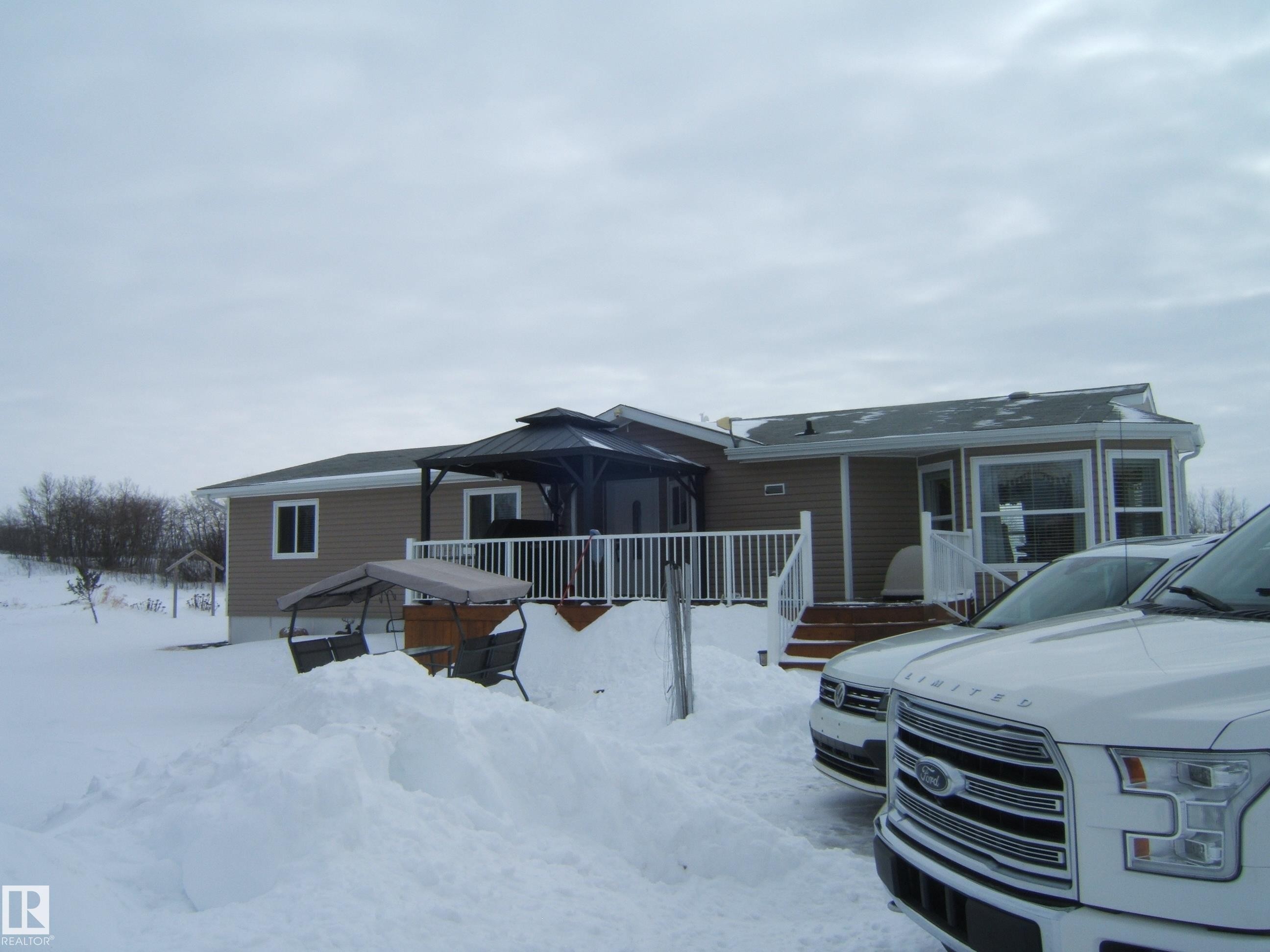 View of front facade with a gazebo and a deck - 125076 Twp Rd 540, Rural Two Hills County, AB - Outdoor With Deck Patio Veranda