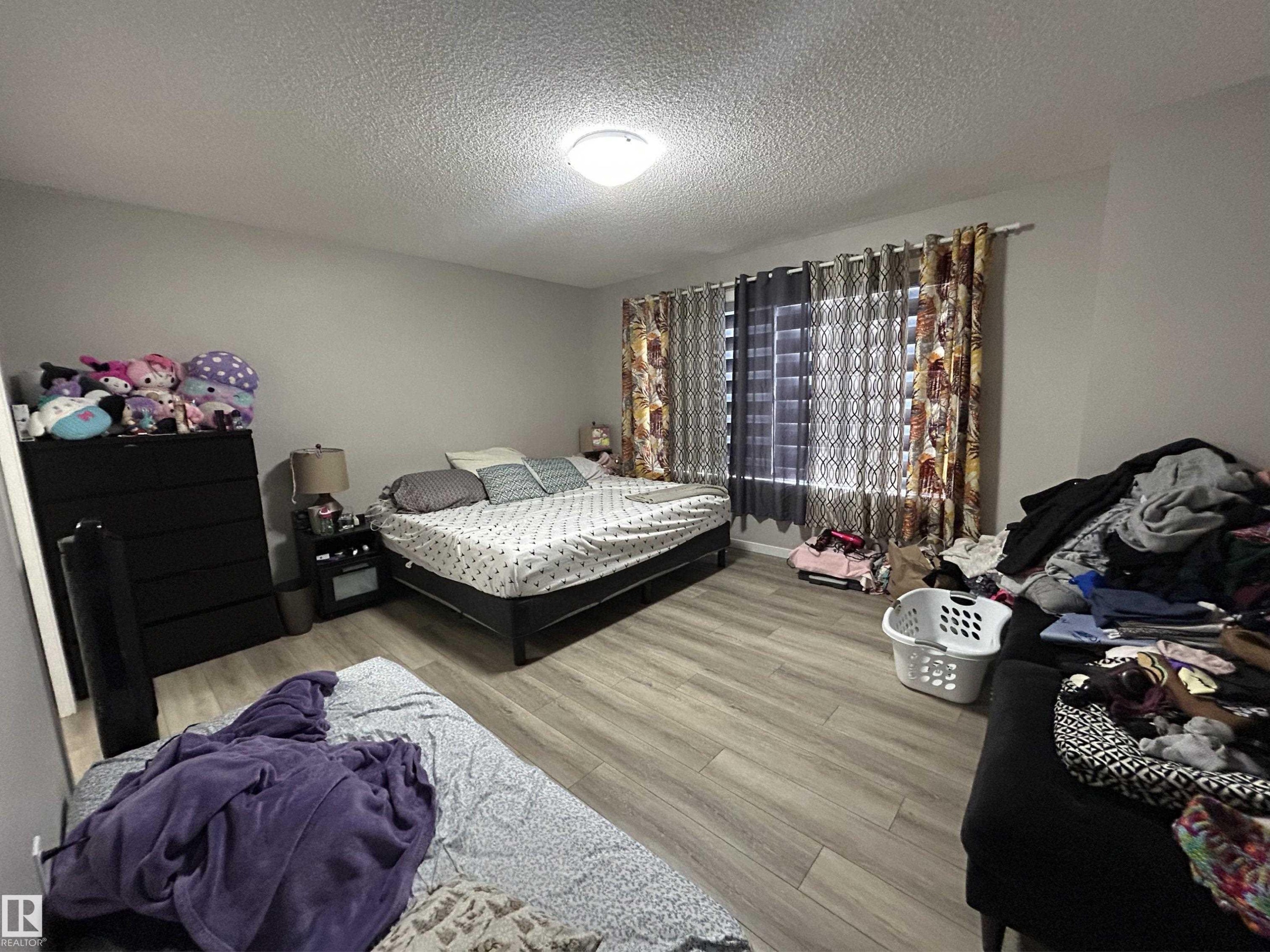 Bedroom featuring light wood-type flooring and a textured ceiling - 120 1530 Tamarack Boulevard, Edmonton, AB - Indoor Photo Showing Bedroom