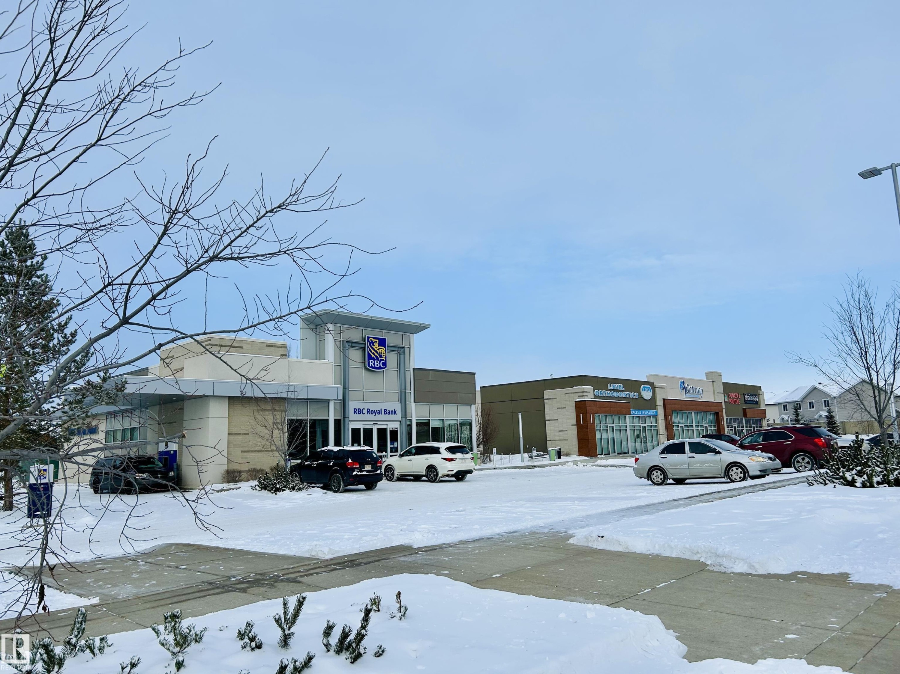 Snow covered building with view of commercial area and uncovered parking - 120 1530 Tamarack Boulevard, Edmonton, AB - Outdoor
