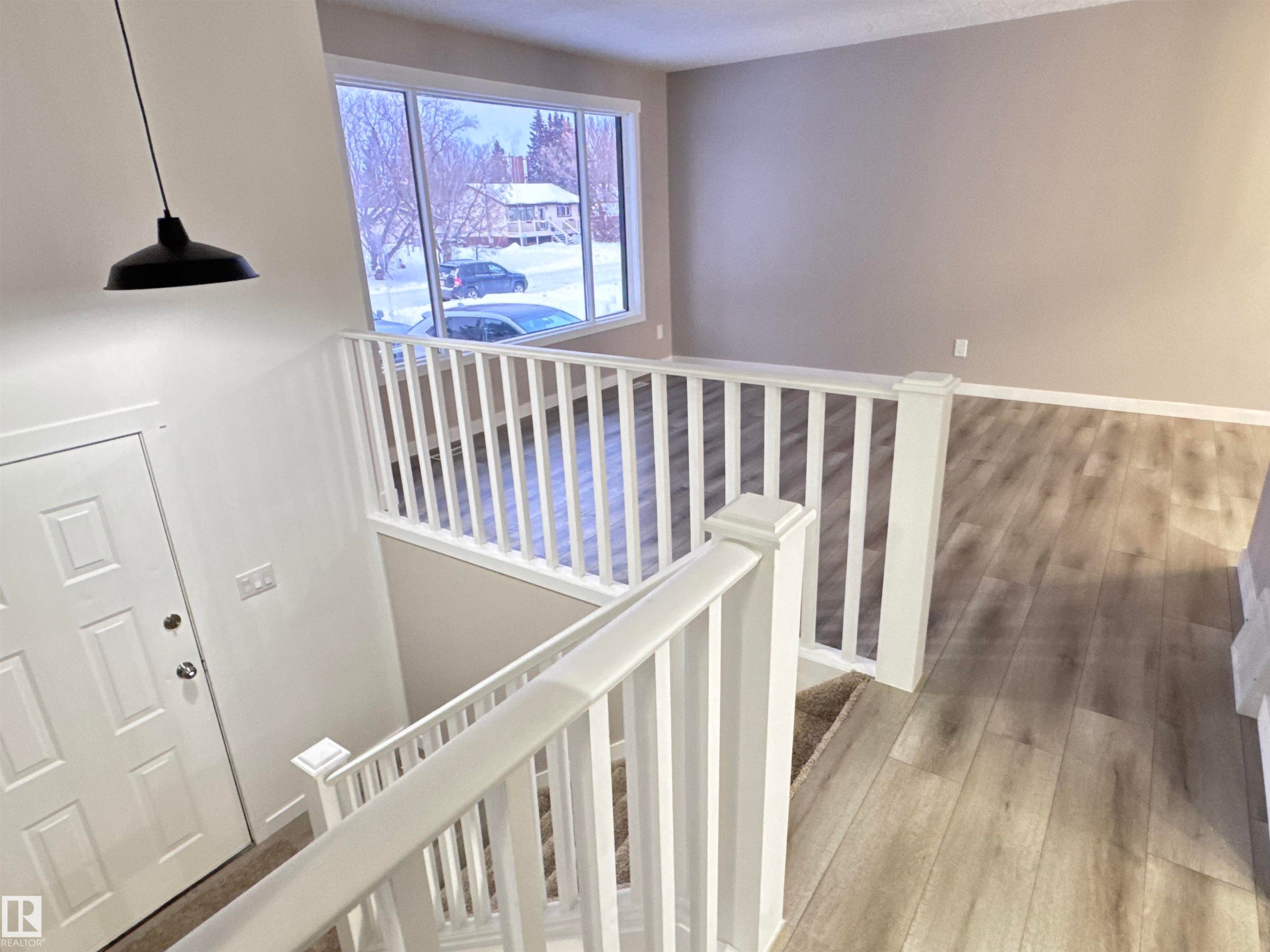 Stairs with hardwood / wood-style floors - 4919 49 Avenue, Vimy, AB - Indoor Photo Showing Other Room