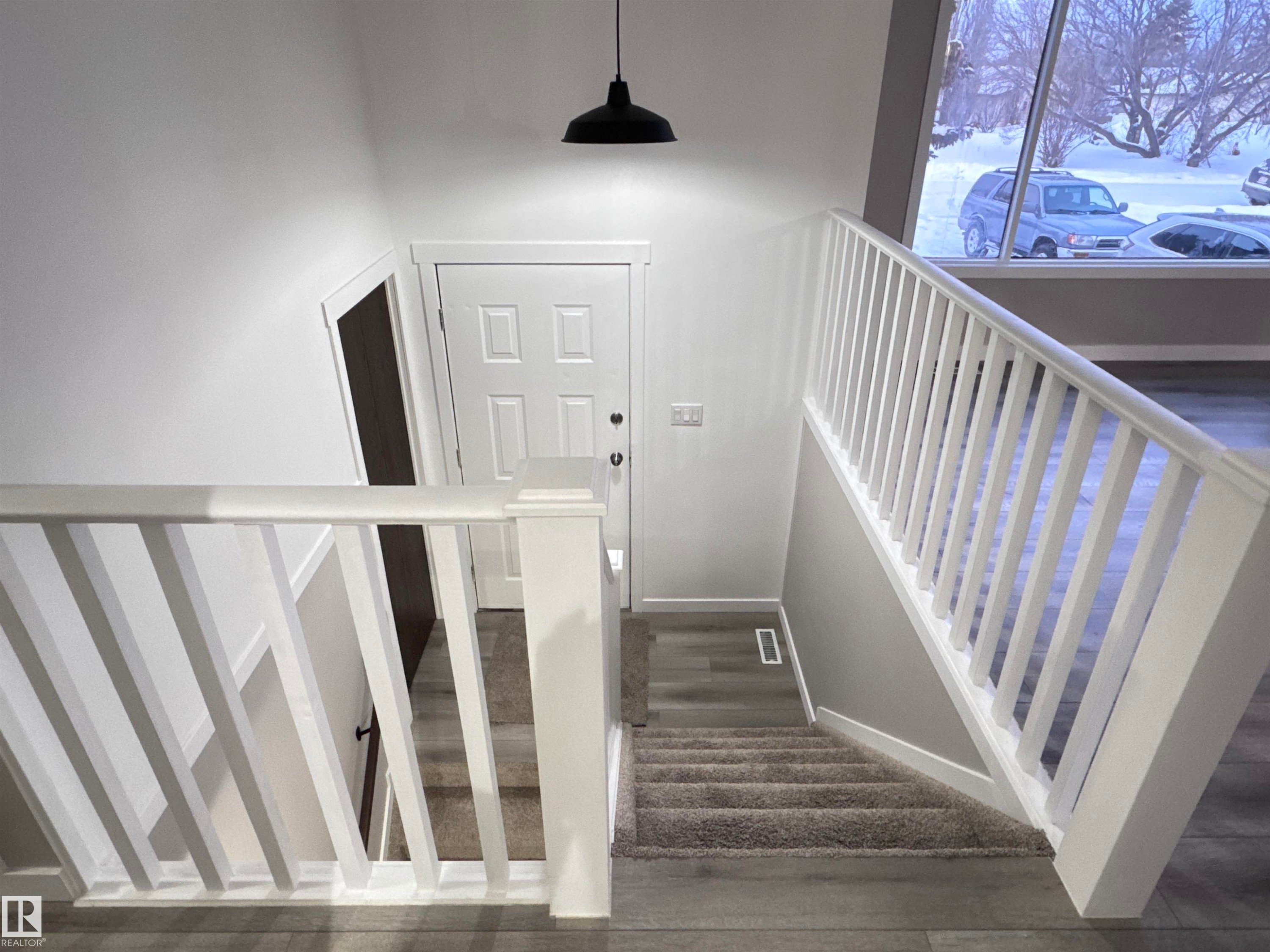Stairs with wood finished floors - 4919 49 Avenue, Vimy, AB - Indoor Photo Showing Other Room