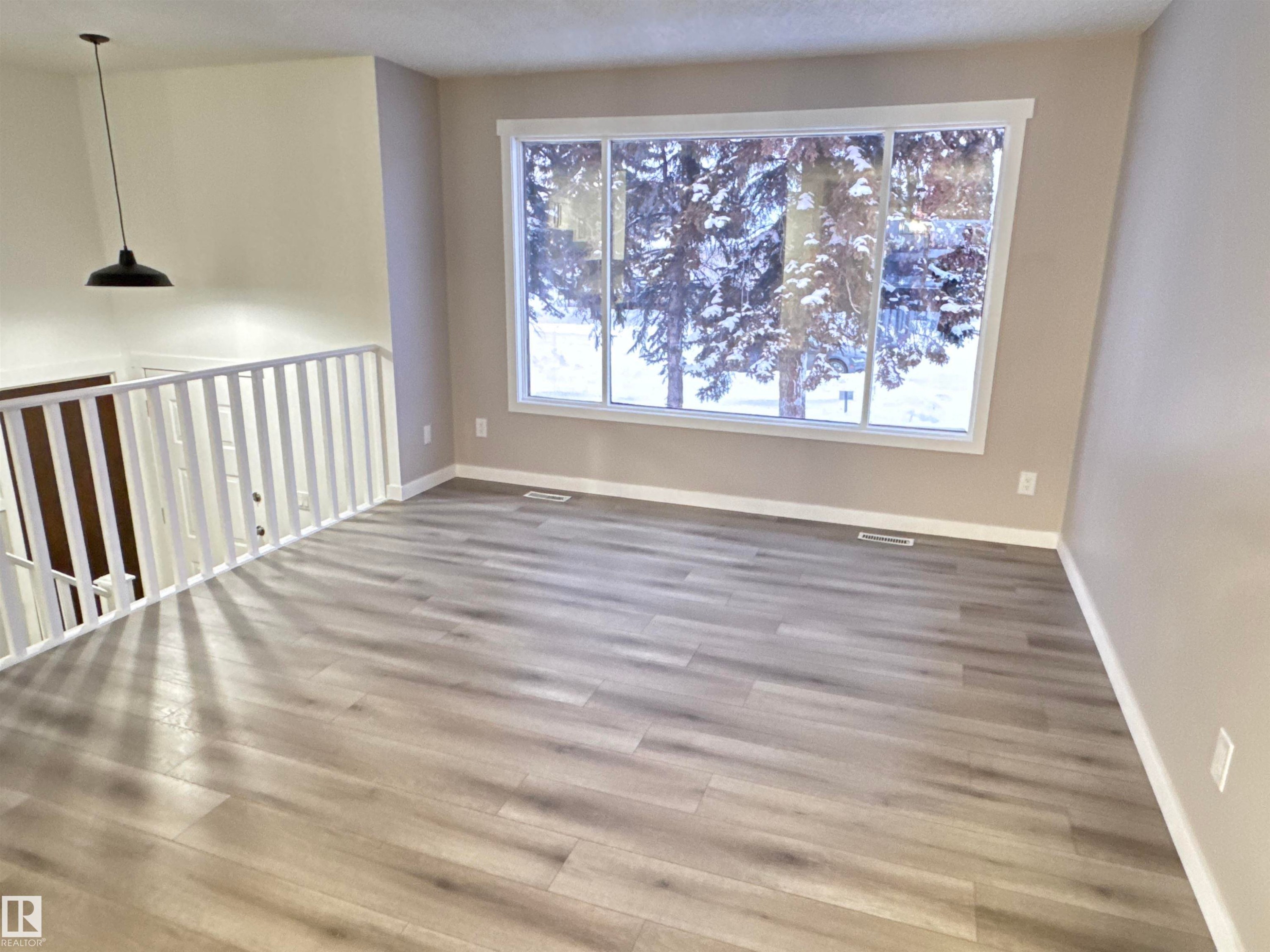 Unfurnished room featuring baseboards and wood finished floors - 4919 49 Avenue, Vimy, AB - Indoor Photo Showing Other Room