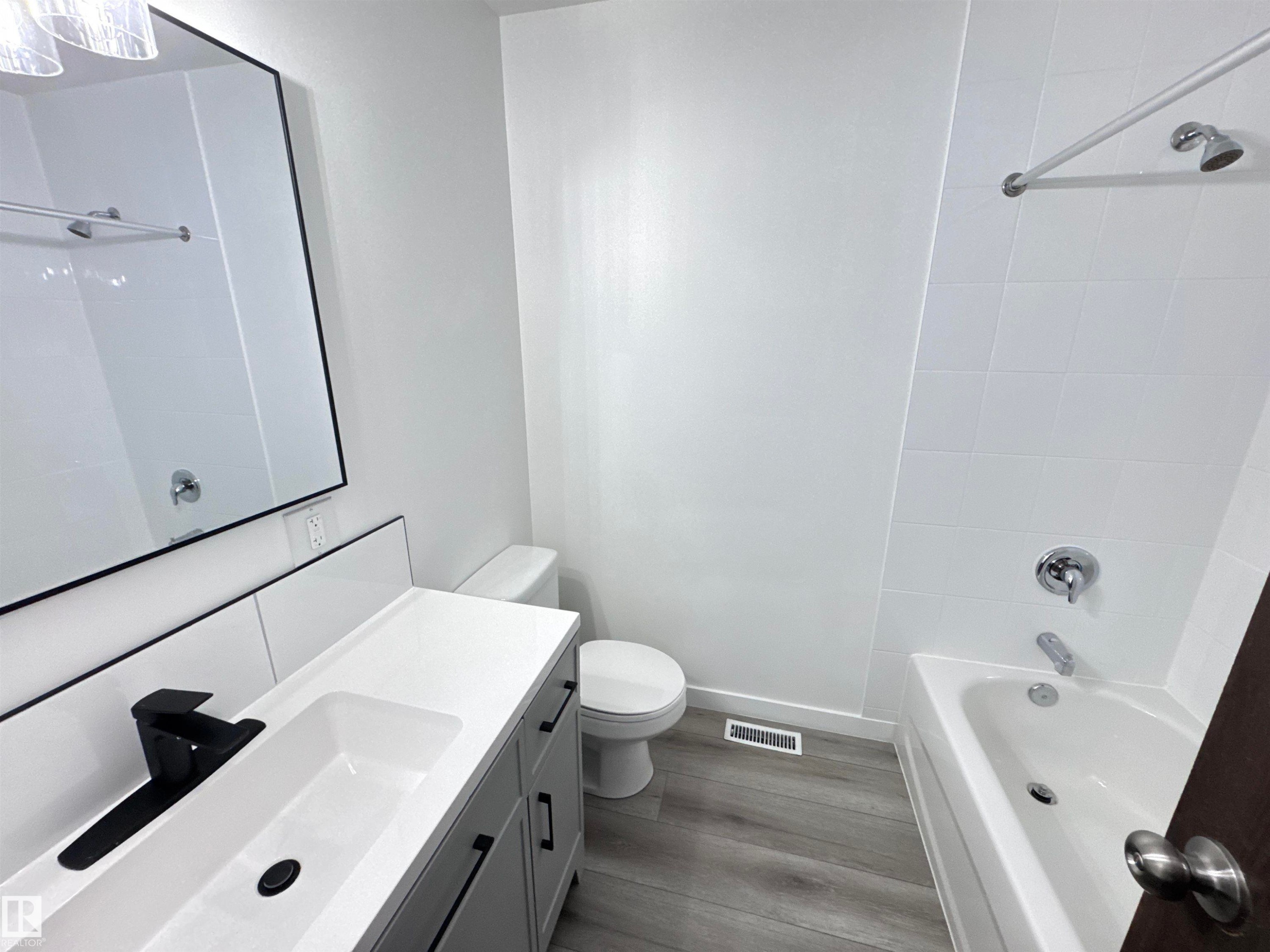 Full bath featuring vanity, light wood-style floors, and shower / washtub combination - 4919 49 Avenue, Vimy, AB - Indoor Photo Showing Bathroom