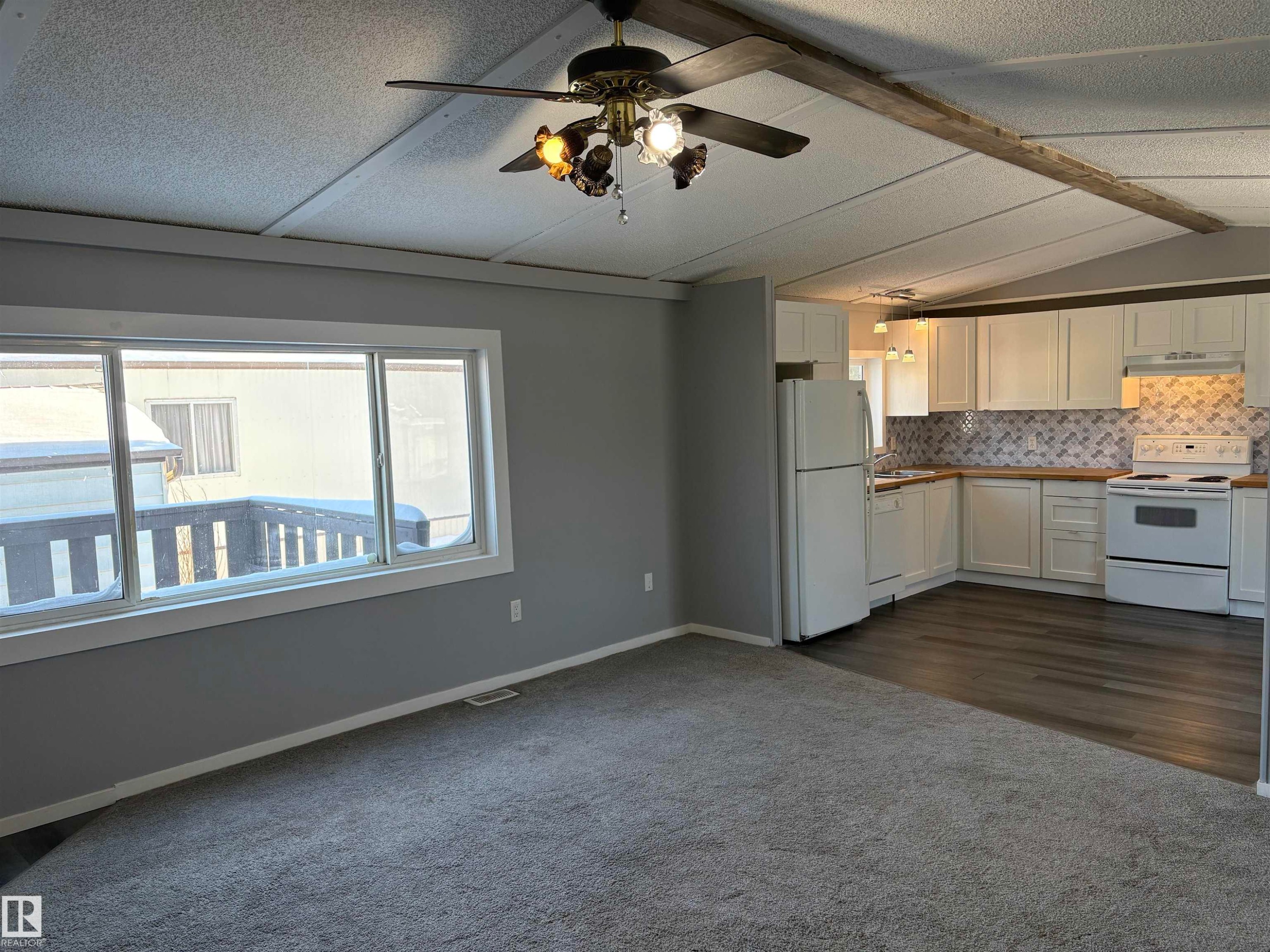 Kitchen featuring white appliances, white cabinetry, backsplash, a textured ceiling, and dark carpet - 8 Evergreen Park Drive, Edmonton, AB - Indoor Photo Showing Kitchen