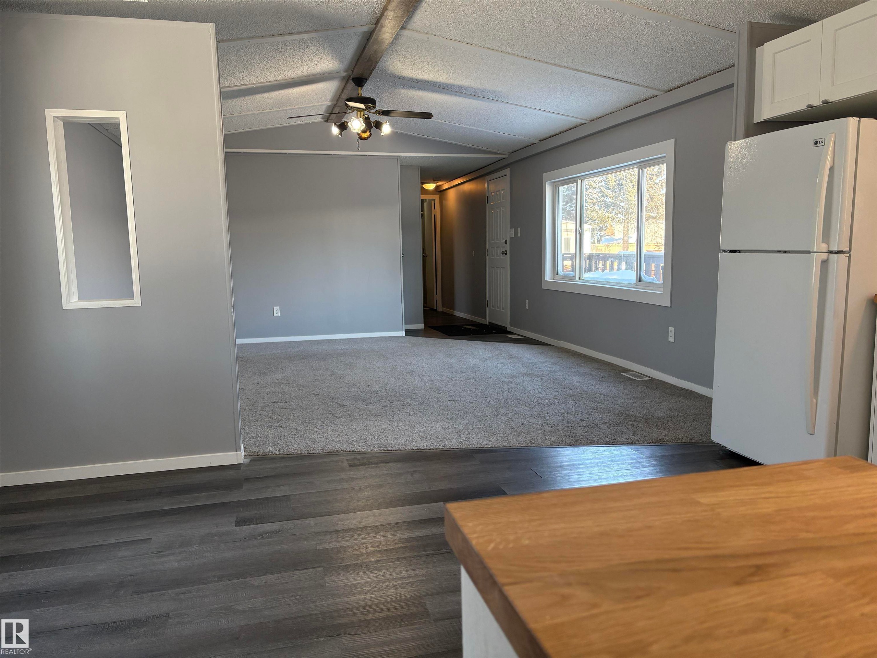Interior space featuring white cabinetry, freestanding refrigerator, ceiling fan, beamed ceiling, and dark wood-style flooring - 8 Evergreen Park Drive, Edmonton, AB - Indoor