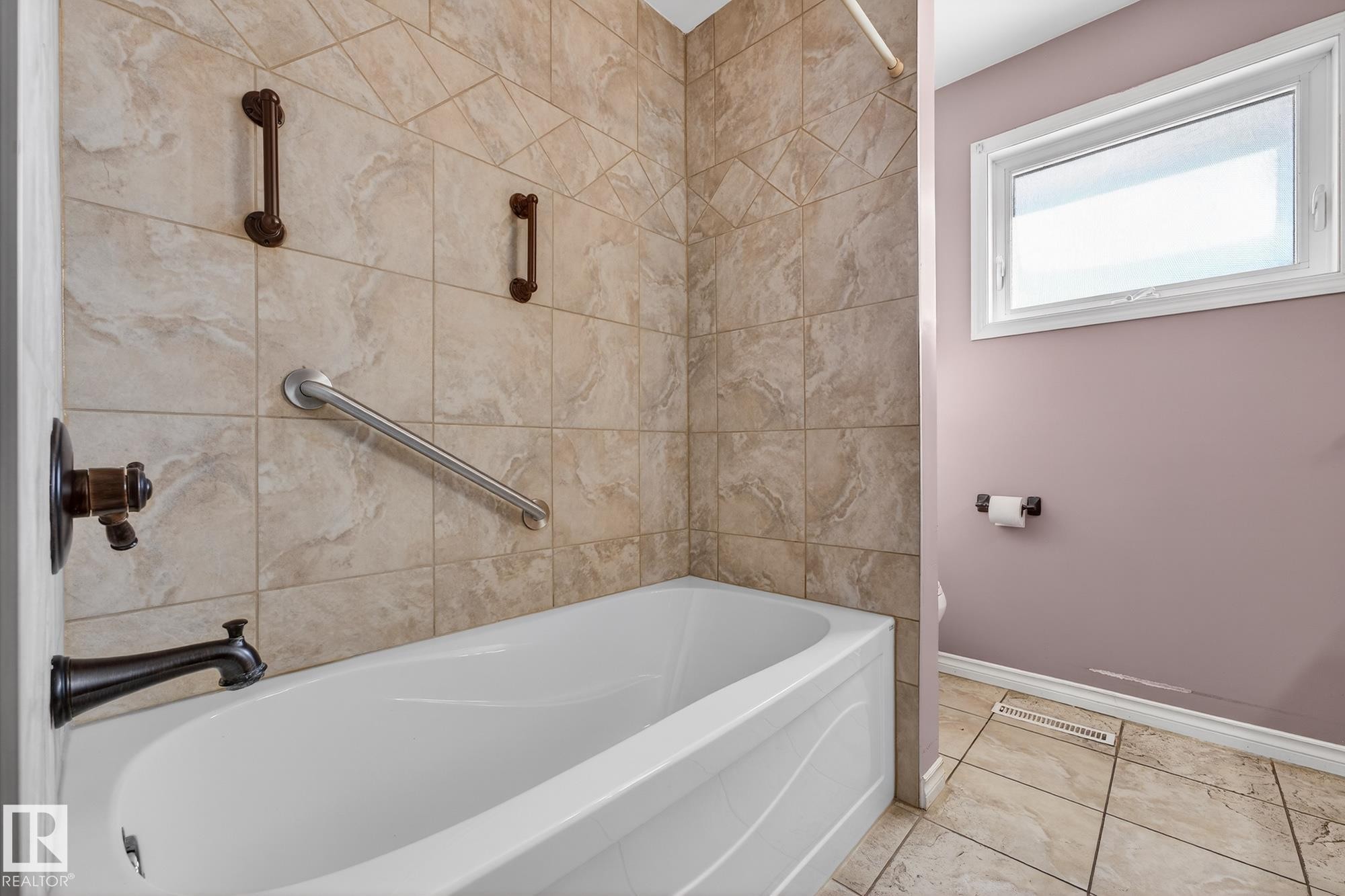 Bathroom featuring baseboards and tub / shower combination - 4645 115 Avenue, Edmonton, AB - Indoor Photo Showing Bathroom