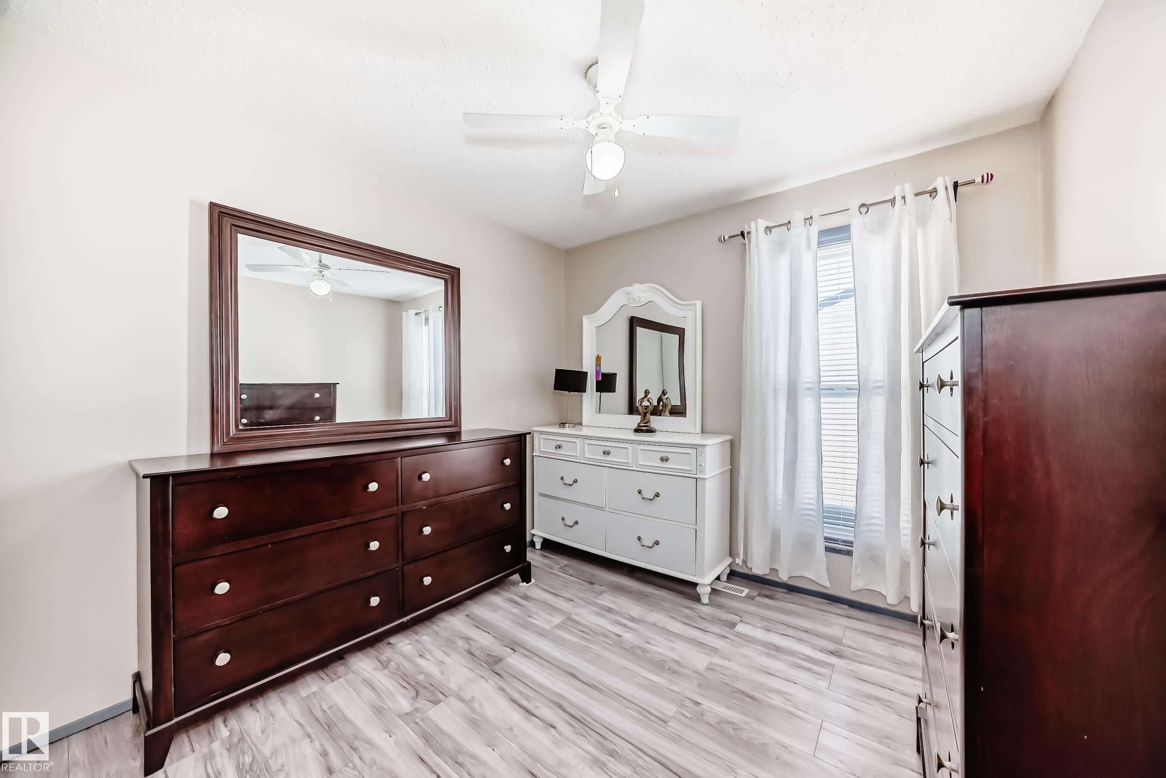 Bedroom featuring light wood-style flooring and ceiling fan - 214A Warwick Road, Edmonton, AB - Indoor Photo Showing Bedroom