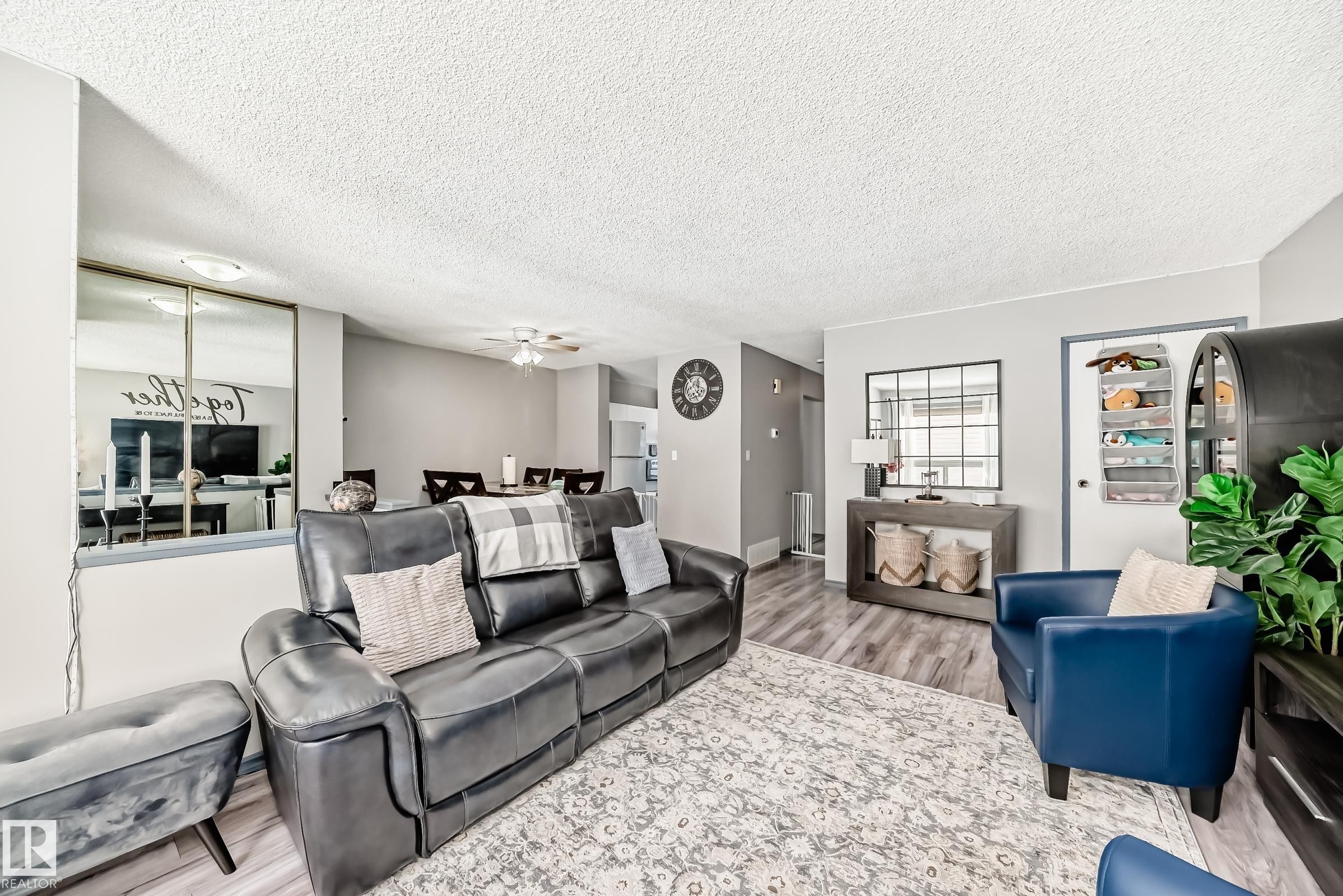 Living area featuring wood finished floors, a textured ceiling, and ceiling fan - 214A Warwick Road, Edmonton, AB - Indoor Photo Showing Living Room