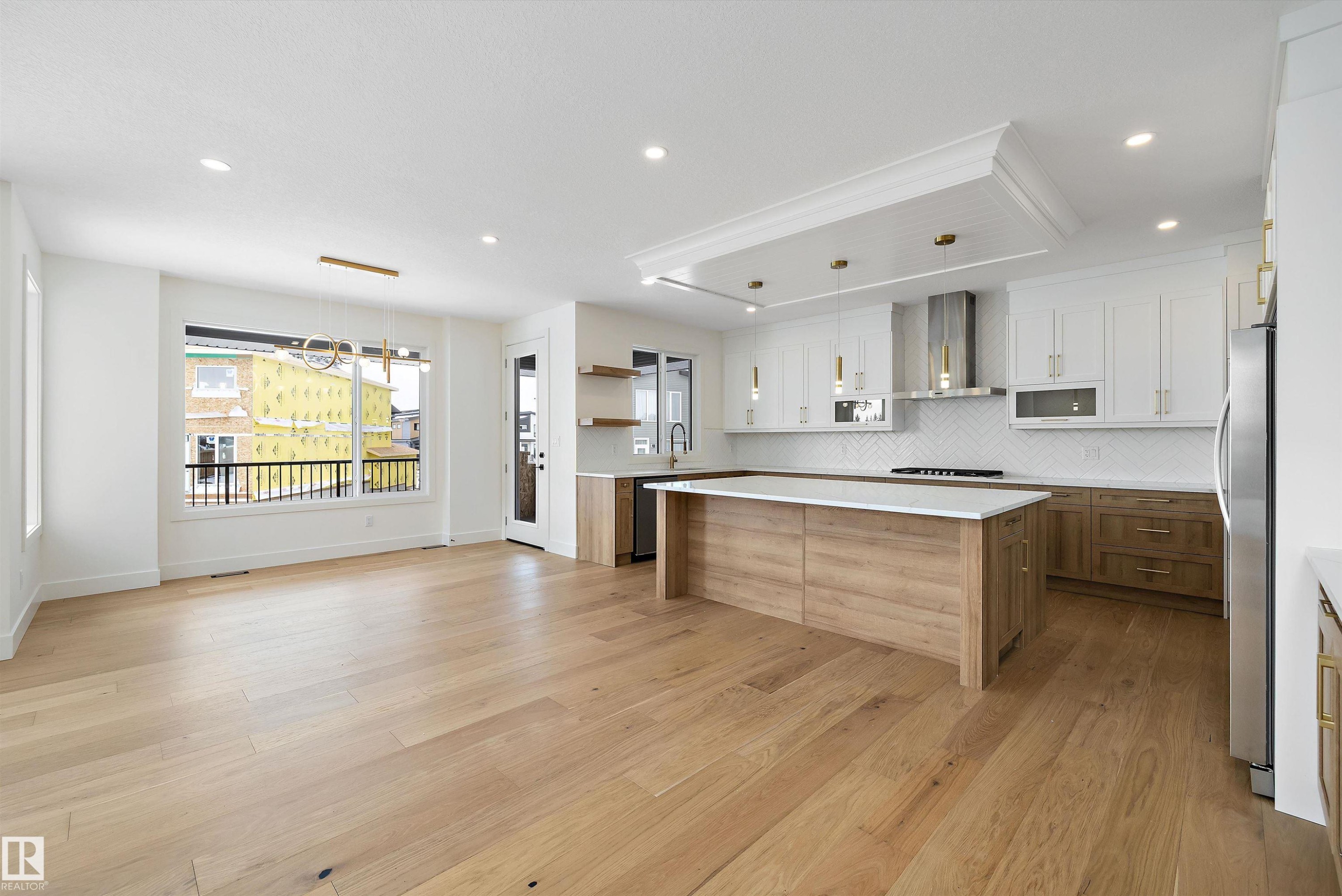 Dual tone kitchen with dual tone cabinets, decorative light fixtures, light wood-style floors, a kitchen island, and open shelves - 6871 Knox Loop Sw, Edmonton, AB - Indoor Photo Showing Other Room