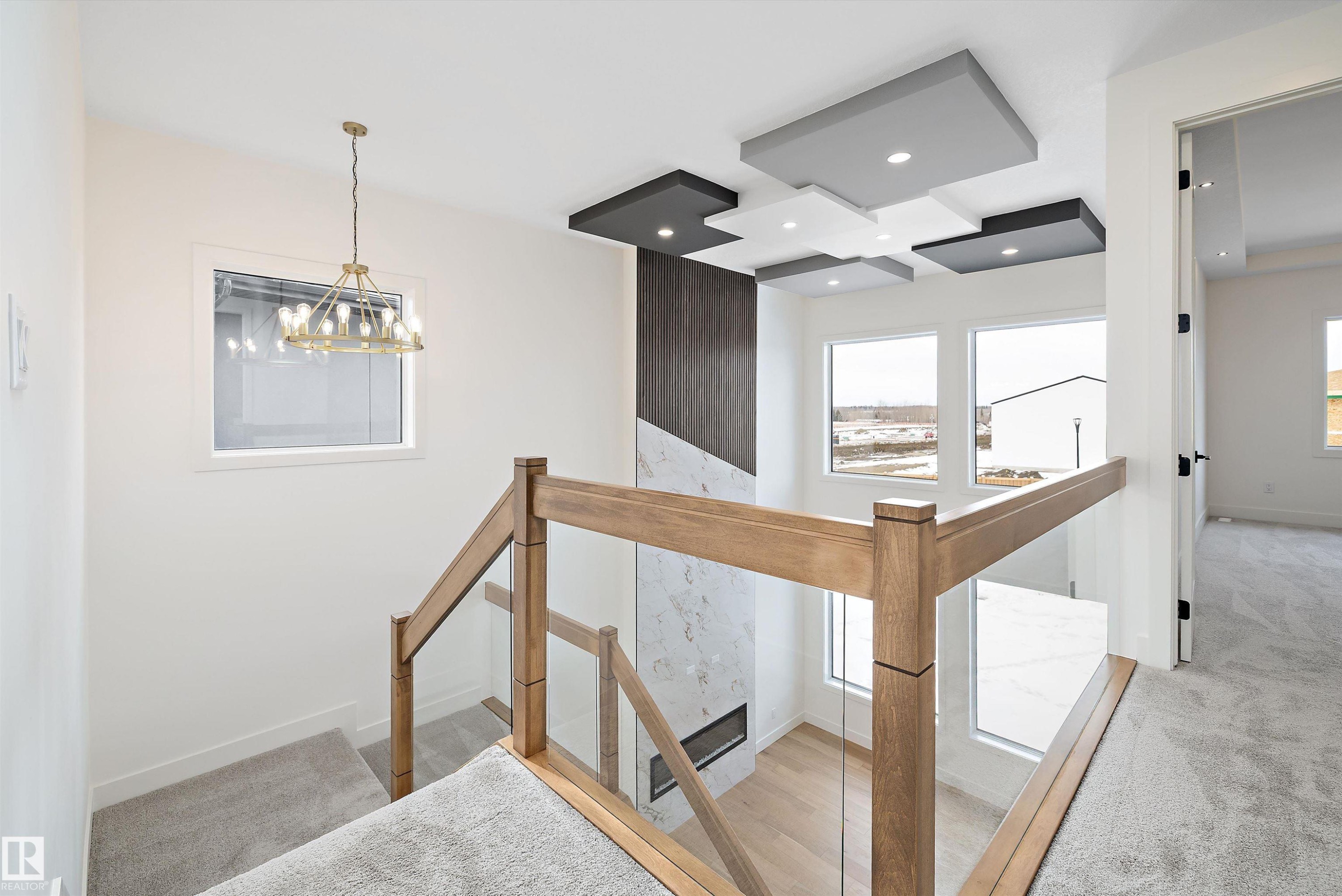Staircase featuring carpet flooring and a chandelier - 6871 Knox Loop Sw, Edmonton, AB - Indoor Photo Showing Other Room