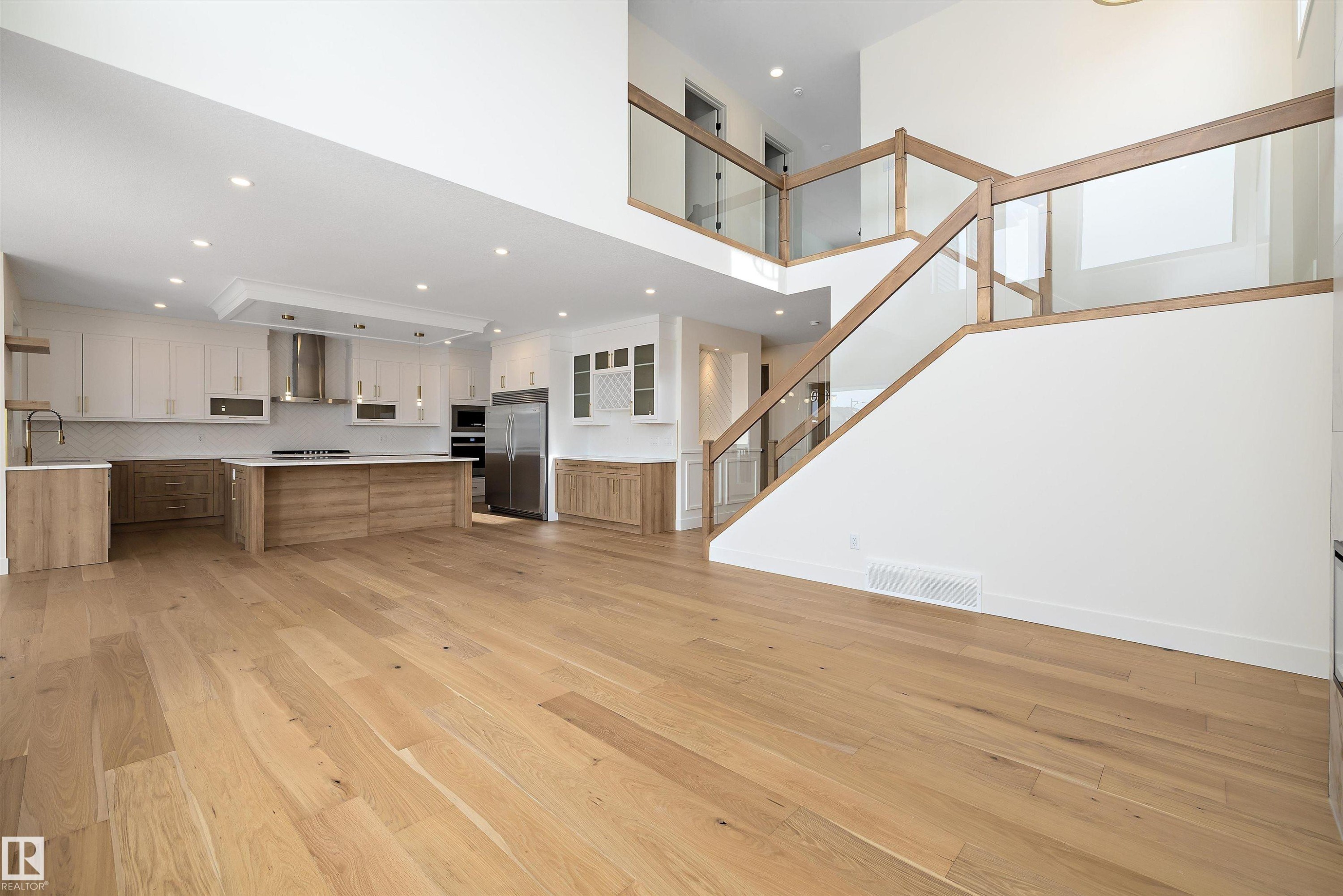 Unfurnished living room with light wood finished floors, recessed lighting, and a high ceiling - 6871 Knox Loop Sw, Edmonton, AB - Indoor