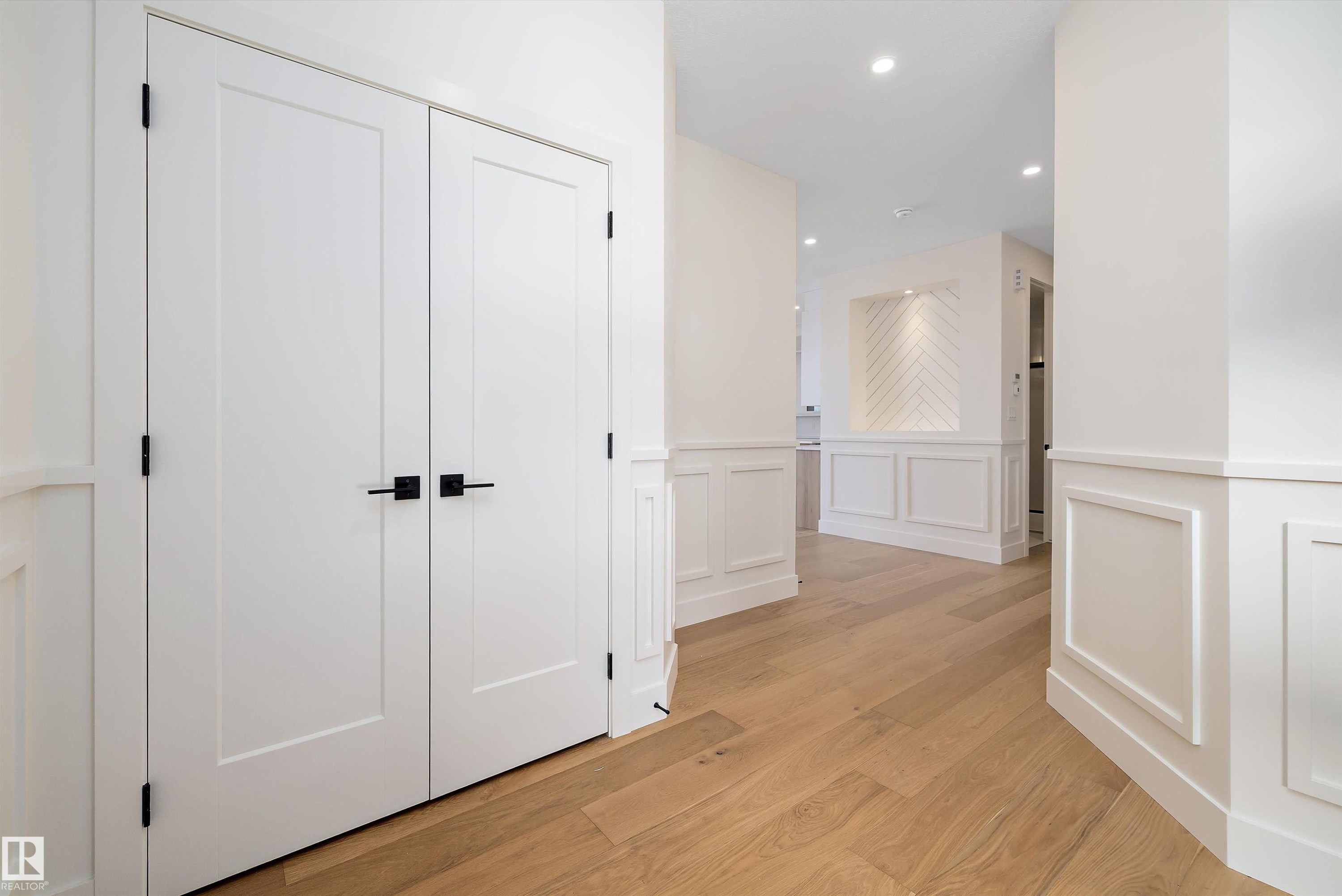 Corridor with wainscoting, light wood-style floors, a decorative wall, and recessed lighting - 6871 Knox Loop Sw, Edmonton, AB - Indoor Photo Showing Other Room