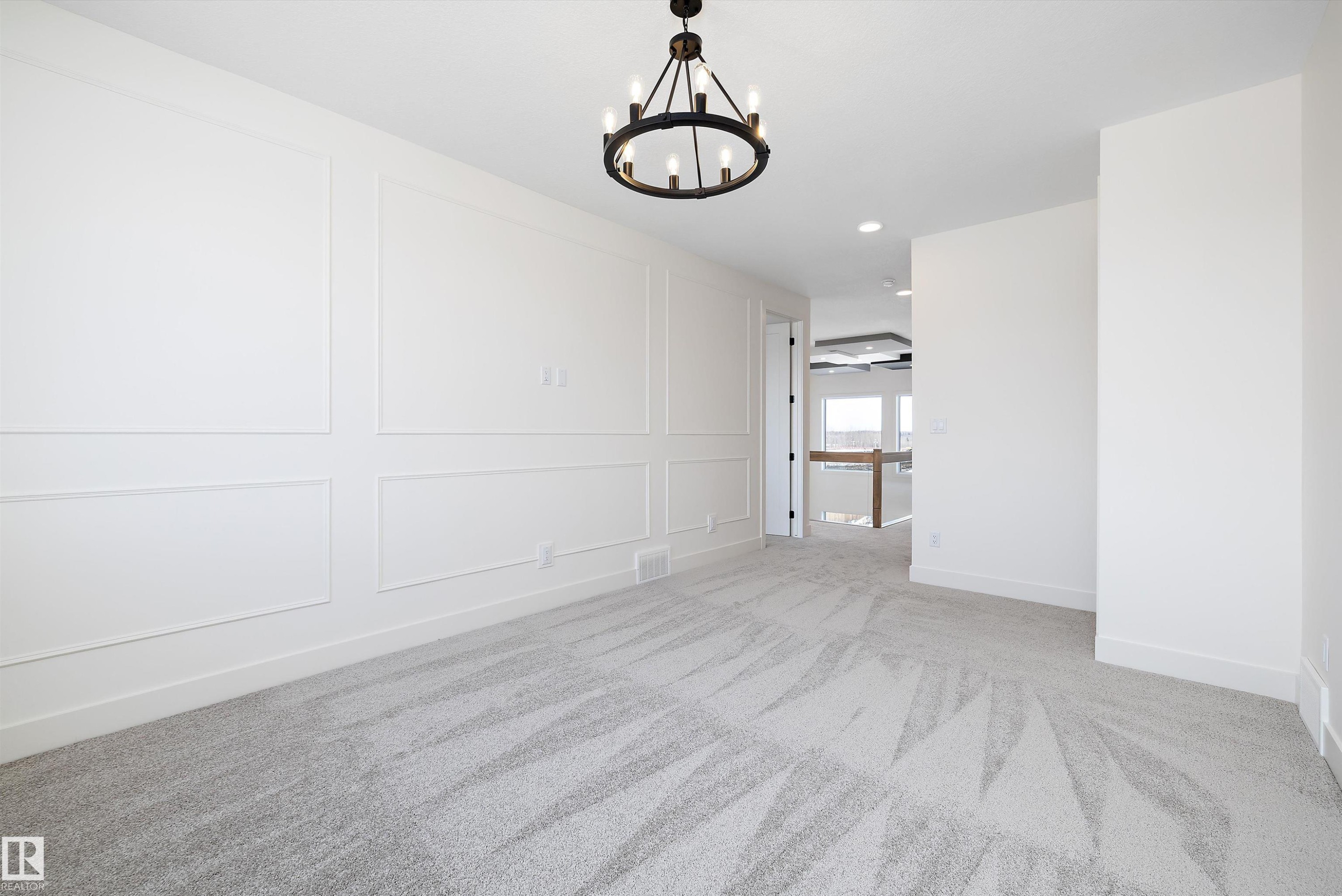 Unfurnished dining area featuring a decorative wall, light carpet, and a chandelier - 6871 Knox Loop Sw, Edmonton, AB - Indoor Photo Showing Other Room