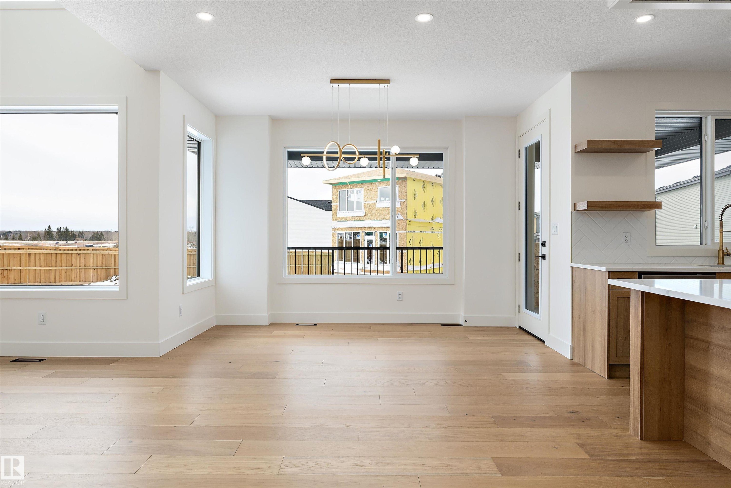 Unfurnished dining area with light wood-type flooring and hanging lights - 6871 Knox Loop Sw, Edmonton, AB - Indoor