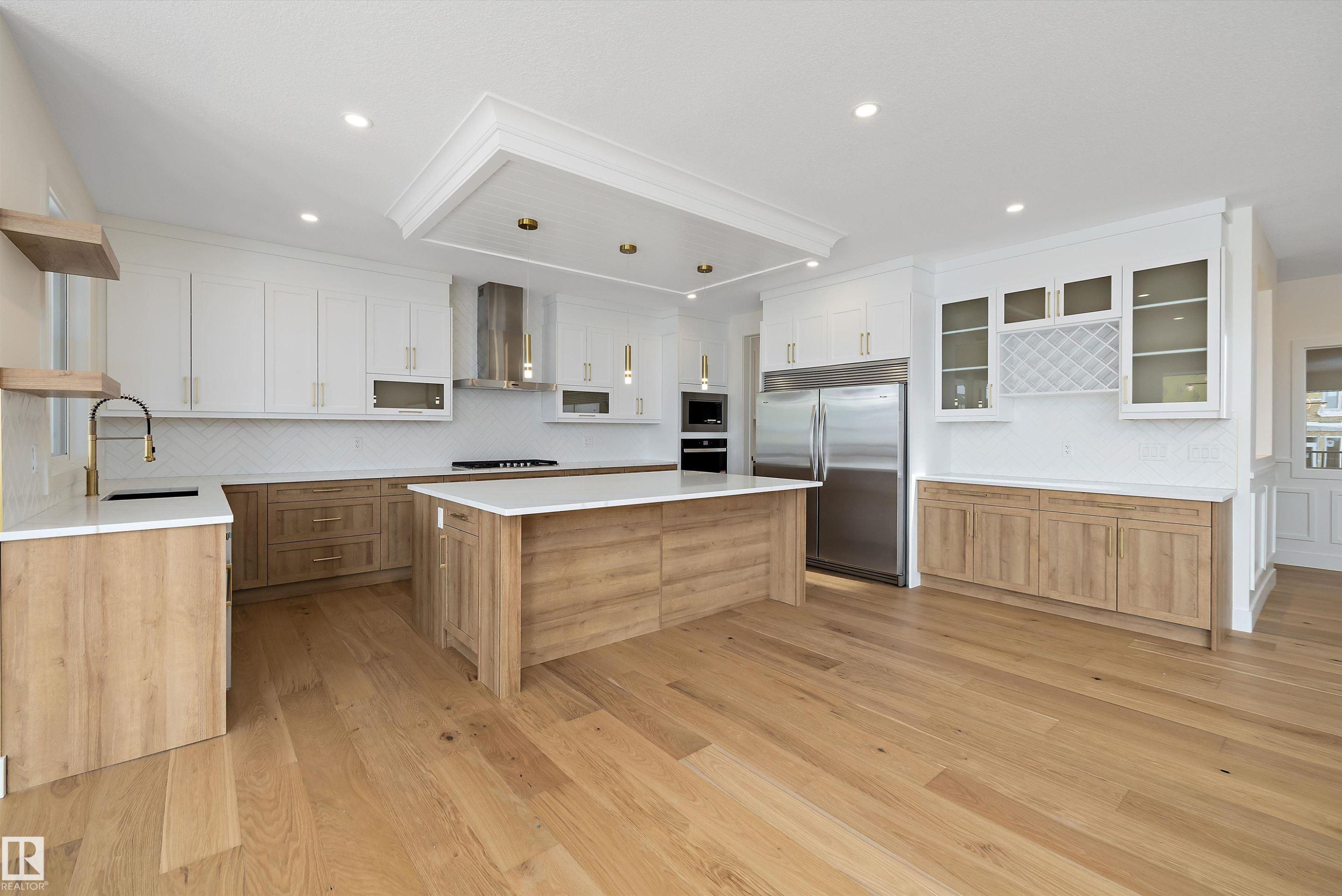 Two tone kitchen featuring dual tone cabinetry, backsplash, open shelves, built in appliances, and light wood-type flooring - 6871 Knox Loop Sw, Edmonton, AB - Indoor Photo Showing Kitchen