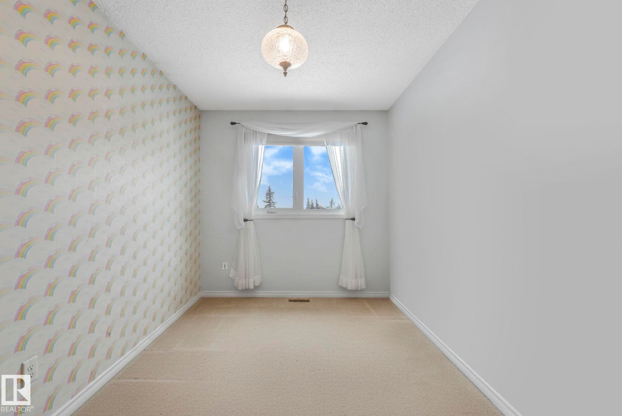 Carpeted spare room featuring a textured ceiling and wallpapered walls - 15909 112 B Street Nw, Edmonton, AB - Indoor Photo Showing Other Room
