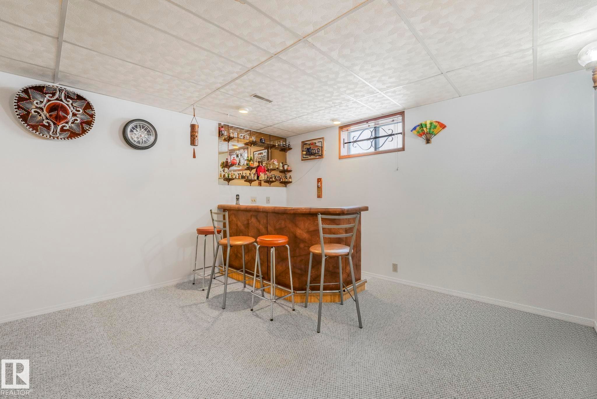 Indoor bar with carpet flooring and a paneled ceiling - 15909 112 B Street Nw, Edmonton, AB - Indoor Photo Showing Other Room