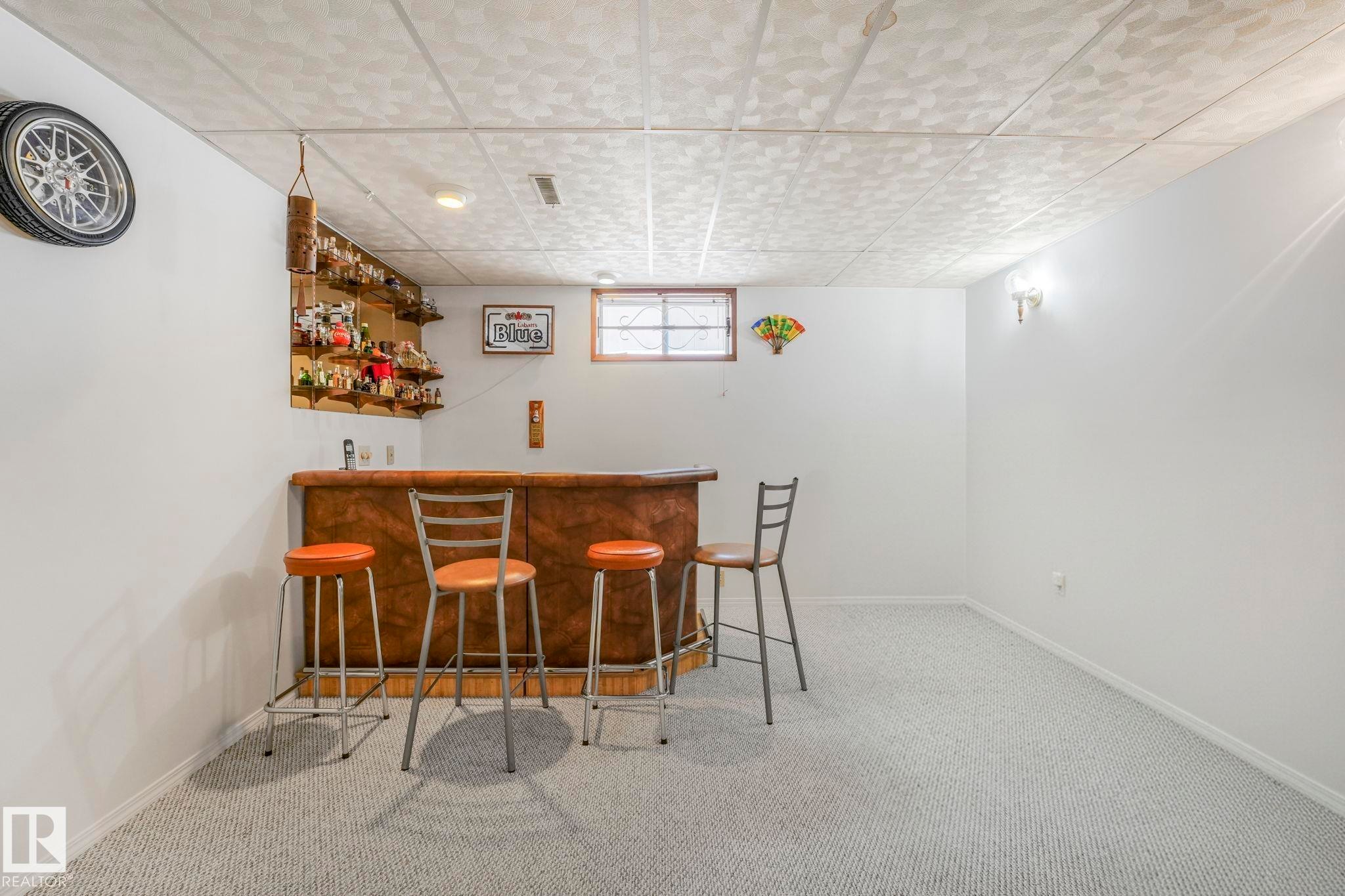 Indoor bar featuring baseboards and carpet - 15909 112 B Street Nw, Edmonton, AB - Indoor