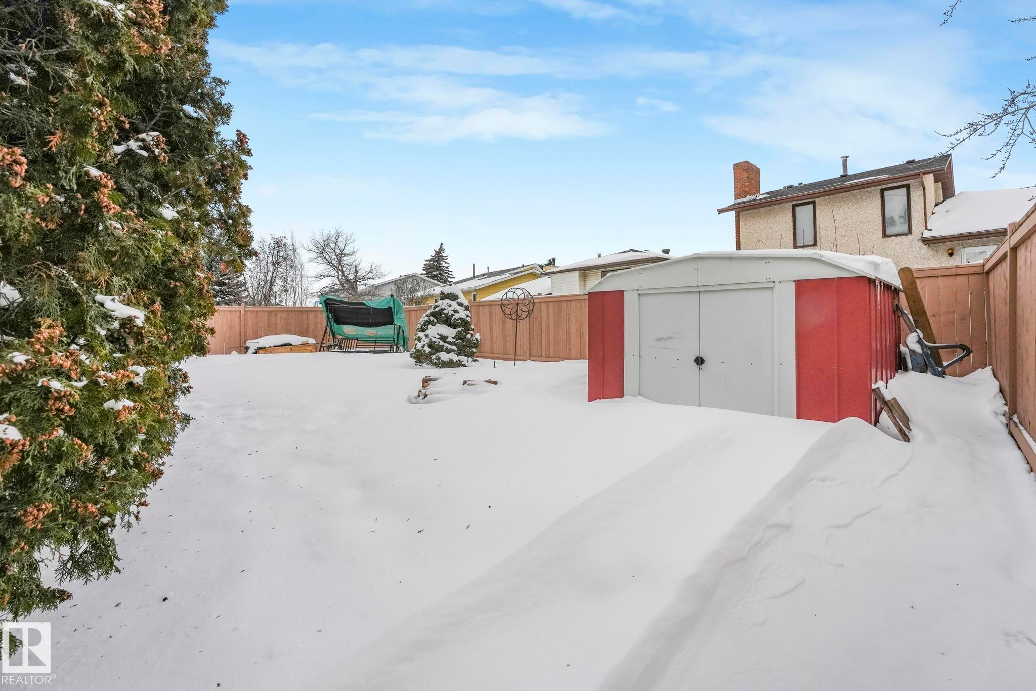 Snowy yard with a fenced backyard and a shed - 15909 112 B Street Nw, Edmonton, AB - Outdoor