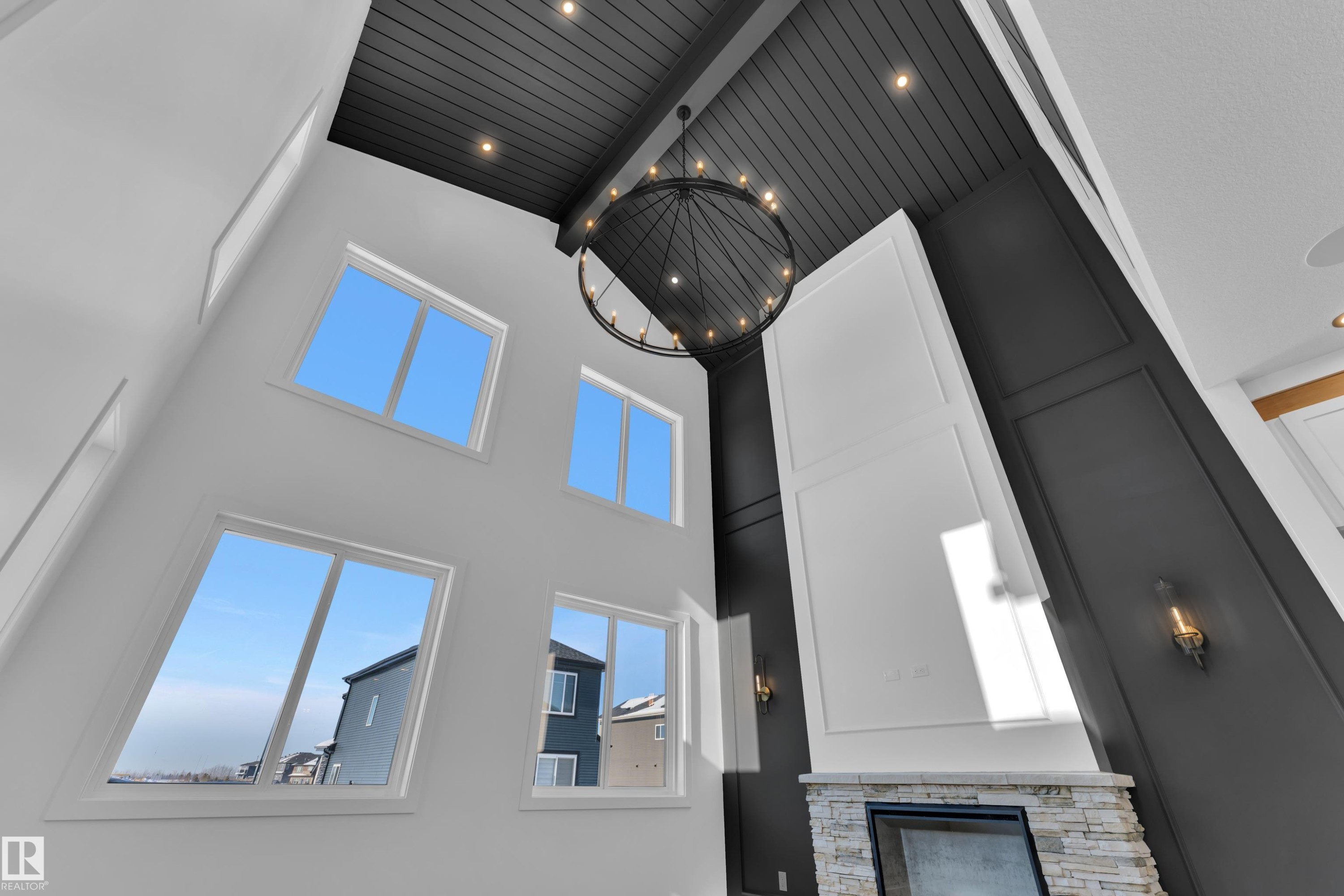 Detailed view of beam ceiling, a stone fireplace, and hanging lights - 95 Eldridge Point(E), St. Albert, AB - Photo Showing Other Room