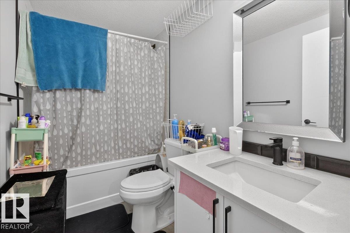 Bedroom with wood finished floors and a textured ceiling - 1027 150 Avenue, Edmonton, AB - Indoor Photo Showing Bathroom
