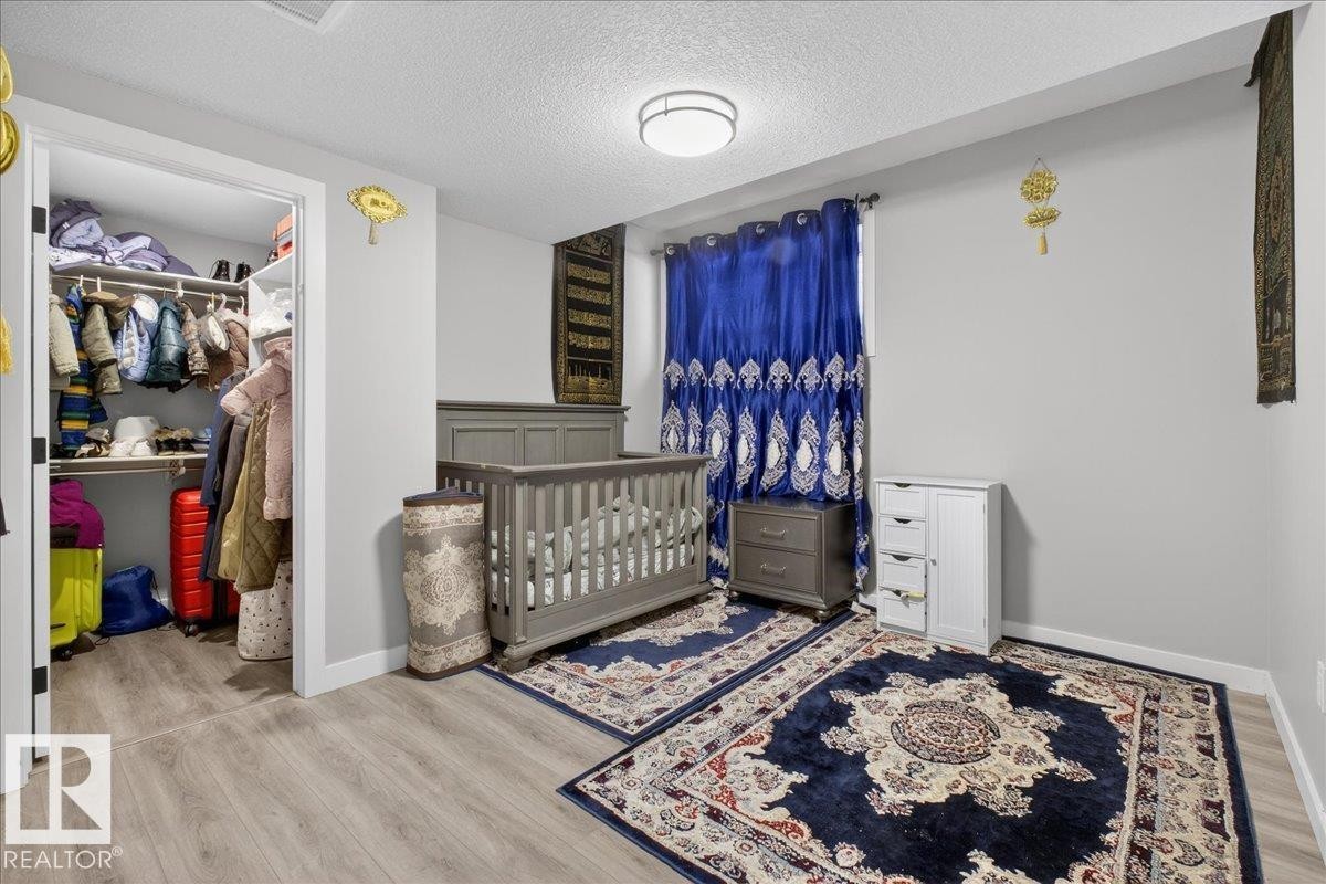 Bathroom featuring vanity, shower / tub combo with curtain, and a textured ceiling - 1027 150 Avenue, Edmonton, AB - Indoor