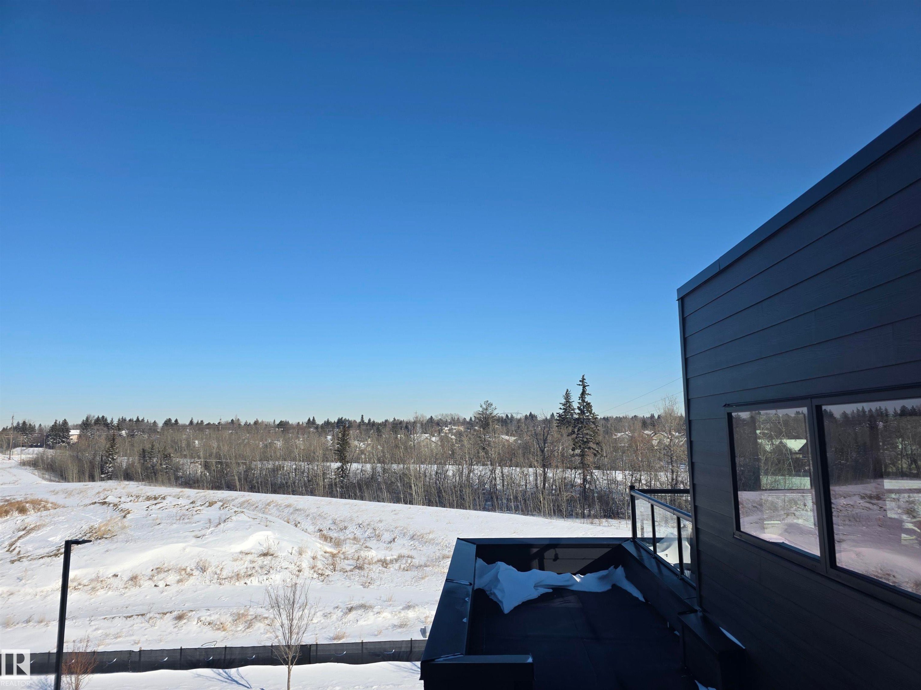 Yard layered in snow with a wooden deck - 77 5 Rondeau Drive, St. Albert, AB - Outdoor With View