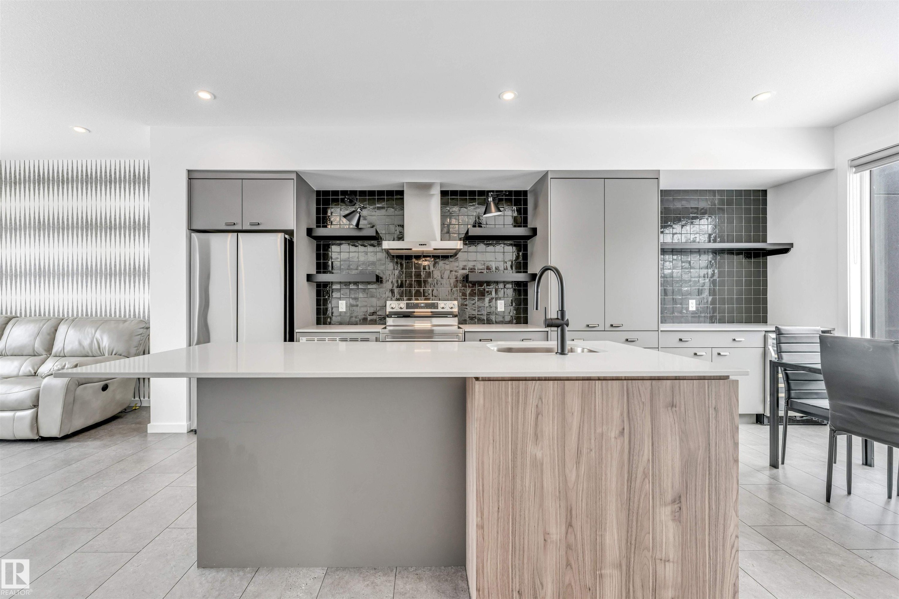 Kitchen with open shelves, two tone cabinets, a center island with sink, stainless steel appliances, and exhaust hood - 77 5 Rondeau Drive, St. Albert, AB - Indoor Photo Showing Kitchen With Upgraded Kitchen