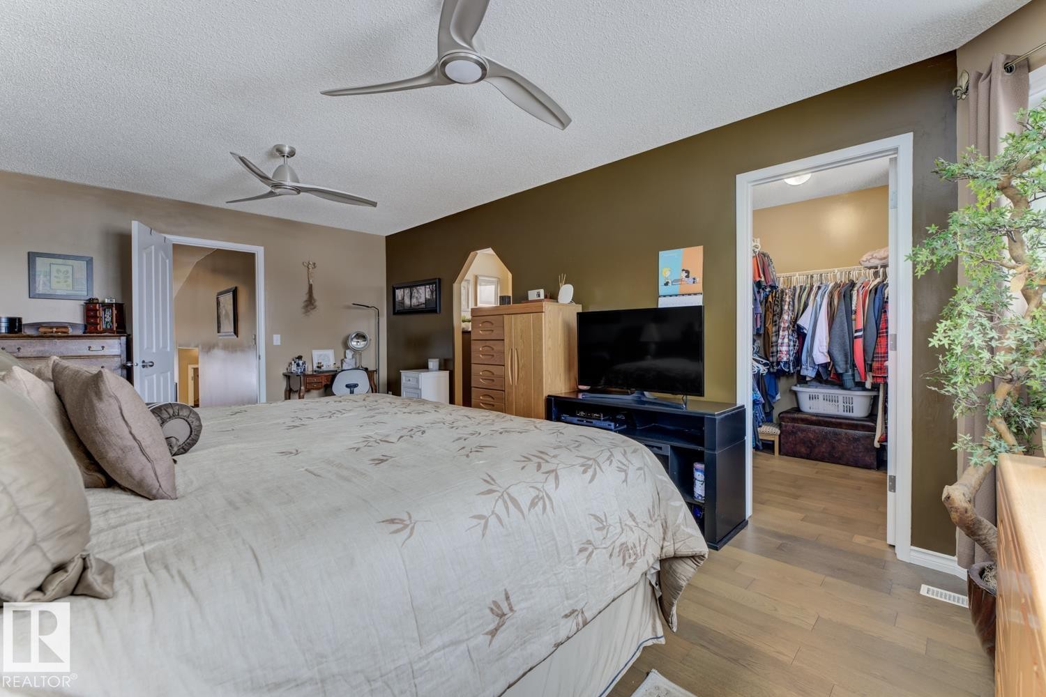 Bedroom with hardwood / wood-style floors, a walk in closet, a textured ceiling, and a ceiling fan - 20148 46 Avenue, Edmonton, AB - Indoor Photo Showing Bedroom