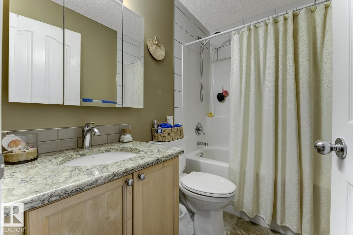Bathroom featuring vanity, shower / bath combination with curtain, and a textured ceiling - 20148 46 Avenue, Edmonton, AB - Indoor Photo Showing Bathroom