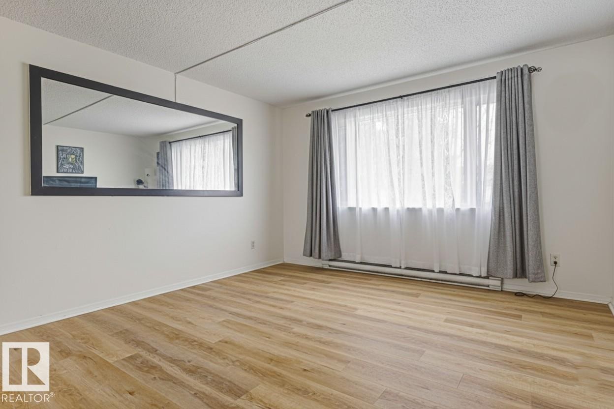 Spare room with light wood-type flooring and a textured ceiling - 13211 71 Street, Edmonton, AB - Indoor Photo Showing Other Room