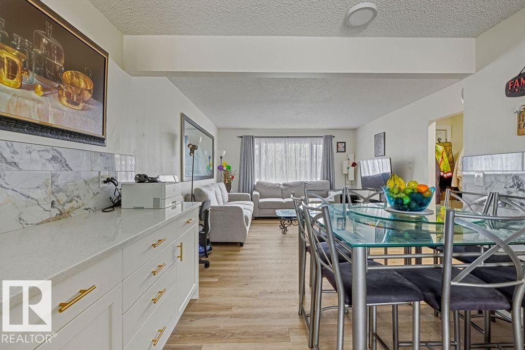 Dining area featuring light wood-style floors and a textured ceiling - 13211 71 Street, Edmonton, AB - Indoor Photo Showing Dining Room