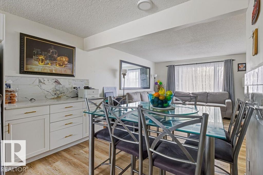 Dining area with a textured ceiling and light wood-type flooring - 13211 71 Street, Edmonton, AB - Indoor Photo Showing Dining Room
