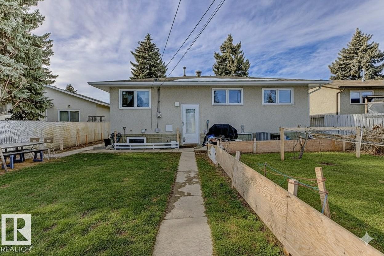 Rear view of property featuring a fenced backyard and stucco siding - 13211 71 Street, Edmonton, AB - Outdoor