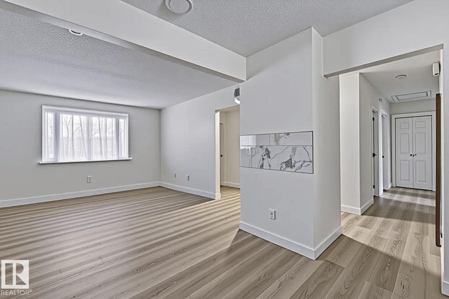 Spare room featuring a textured ceiling and light wood-style floors - 13211 71 Street, Edmonton, AB - Indoor Photo Showing Other Room
