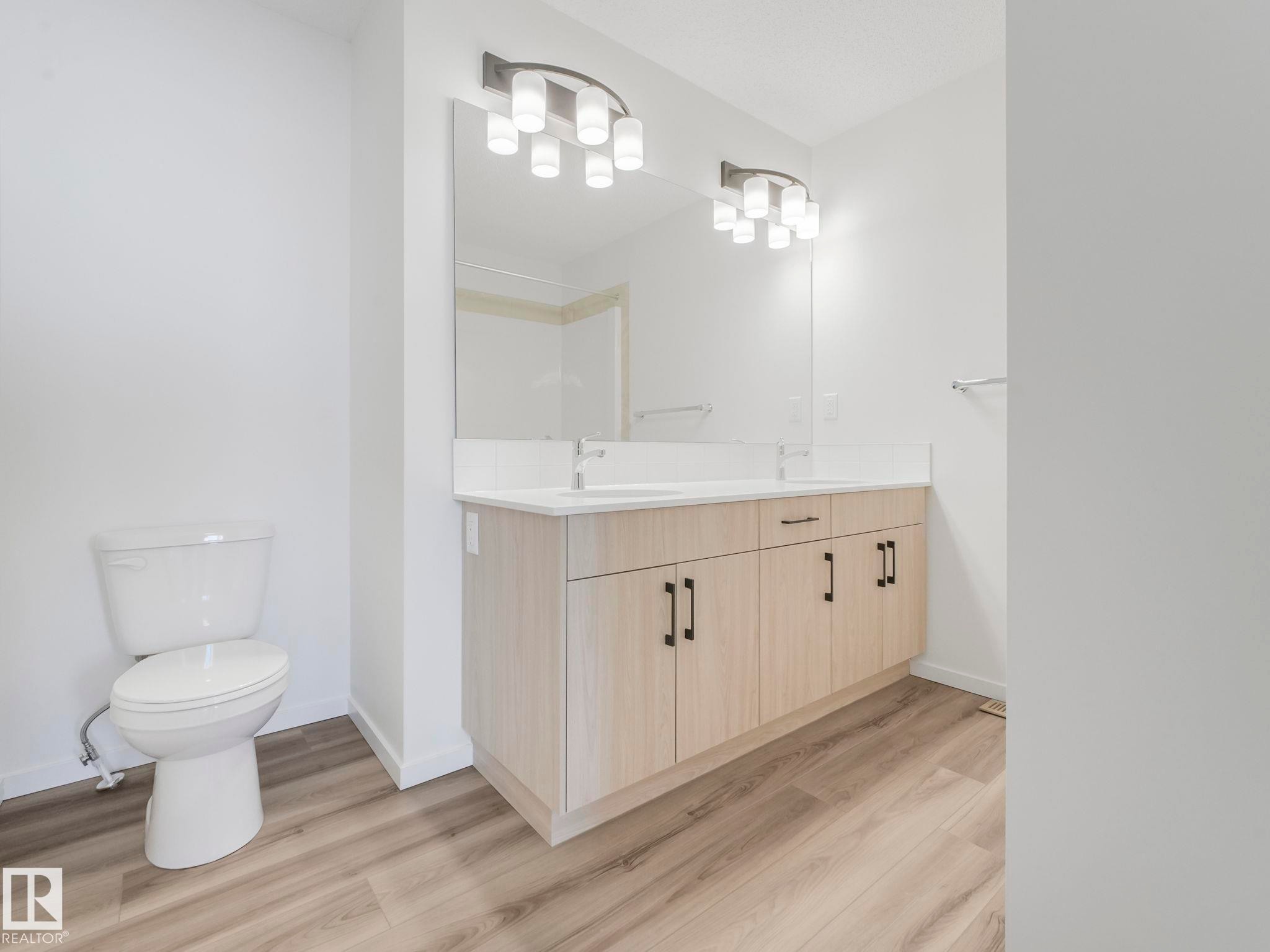 Full bathroom with double vanity, light wood-style floors, and a shower - 20506 16A Avenue, Edmonton, AB - Indoor Photo Showing Bathroom