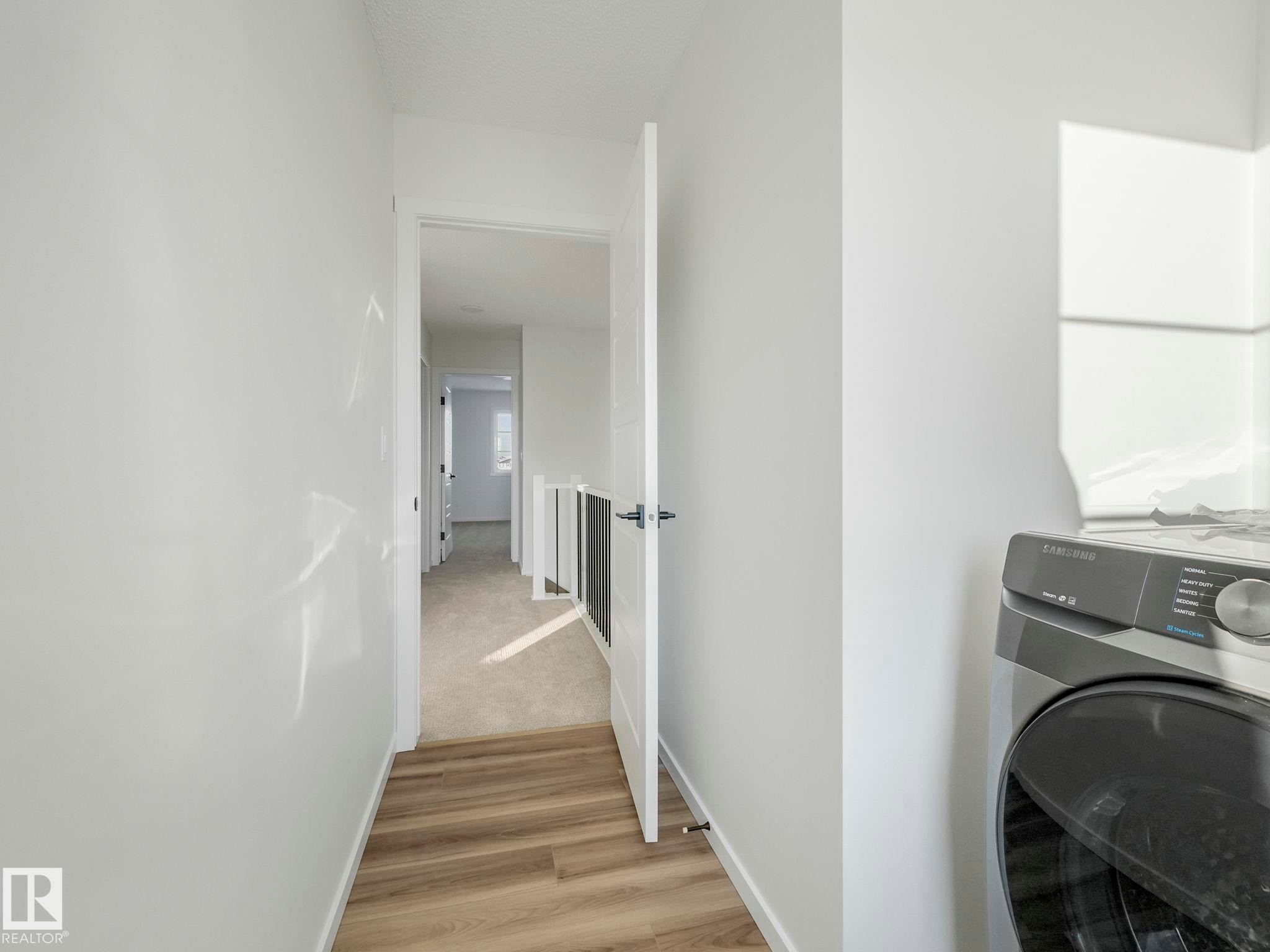 Laundry area featuring washer / dryer and light wood-type flooring - 20506 16A Avenue, Edmonton, AB - Indoor Photo Showing Laundry Room